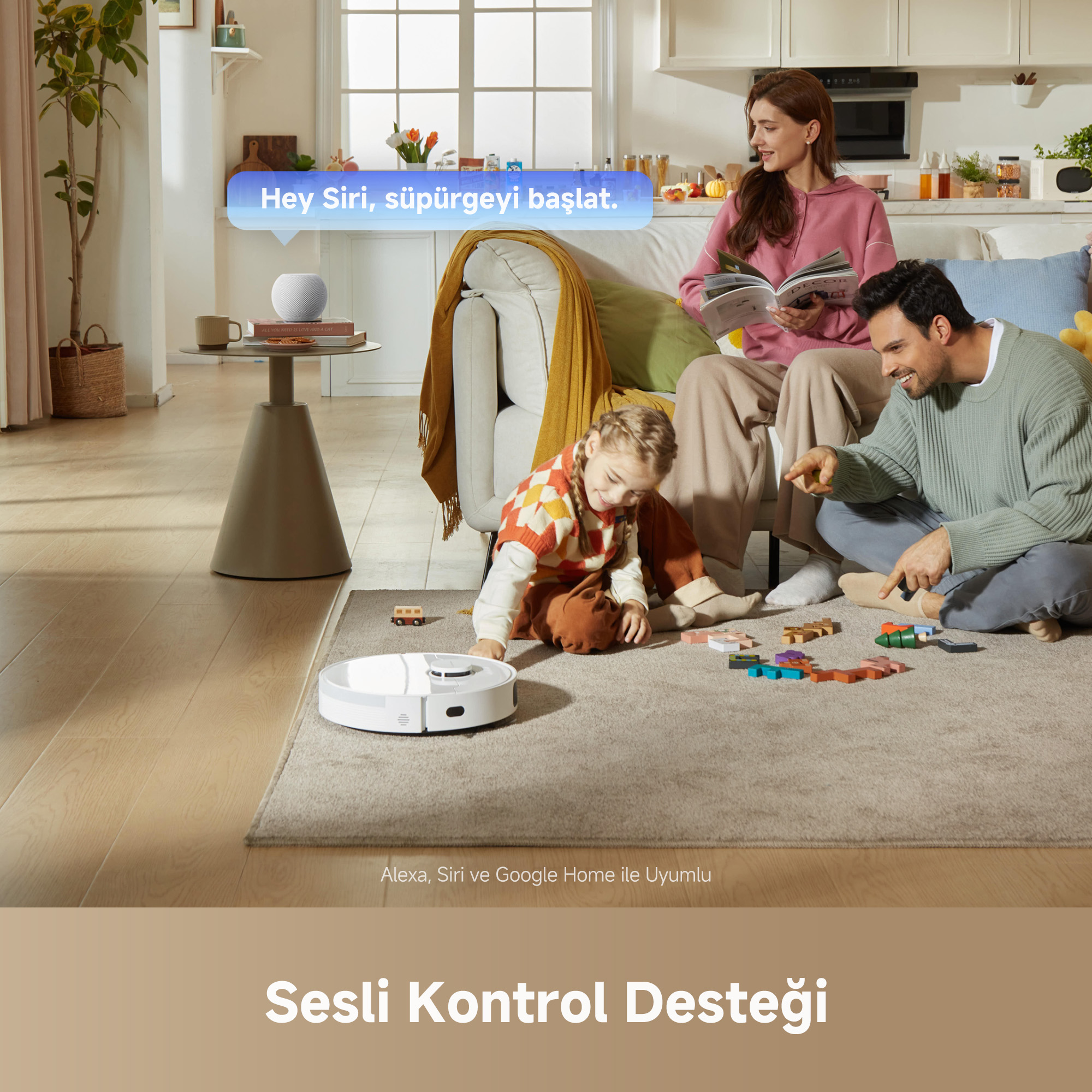Oturma odasında aile; bir çocuk robot süpürgenin yakınında oyuncaklarla oynuyor. Ebeveynler kanepede.