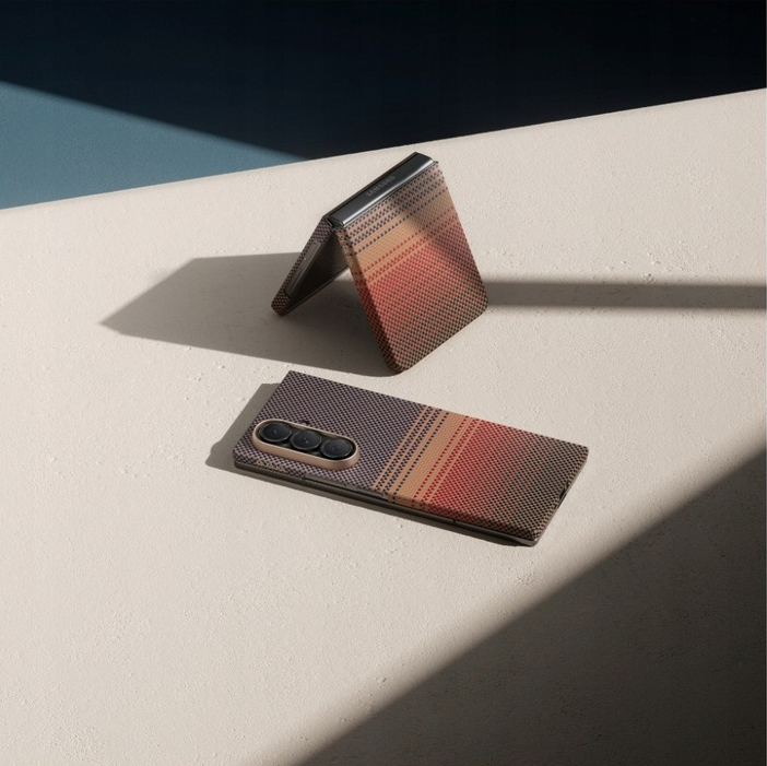 Dwa składane telefony, jeden otwarty, drugi zamknięty. Oba mają wzór w paski brązowe, beżowe i czerwone. Ustawione na jasnej powierzchni.