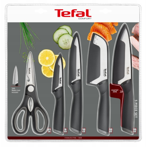 Zestaw noży Tefal 5-częściowy. Zawiera nożyczki, mały nóż i trzy większe noże, wszystkie czarno-srebrne. Warzywa w tle.