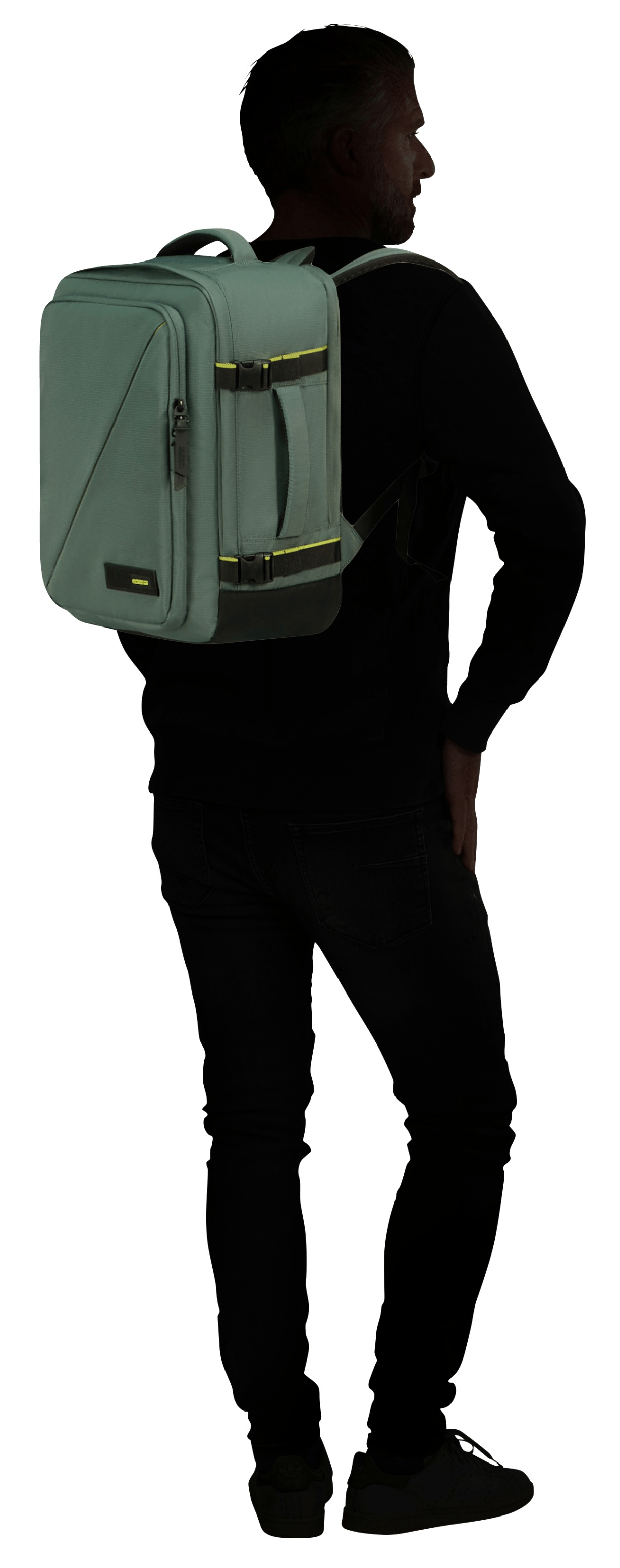 Osoba z tyłu ubrana w czarne ubrania i zielony plecak. Plecak jest na plecach. Osoba stoi.