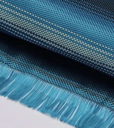 Zbliżenie niebieskiego materiału z tkanym wzorem. Materiał ma frędzle na dole. Kolory wahają się od jasnoniebieskiego do ciemnoniebieskiego.