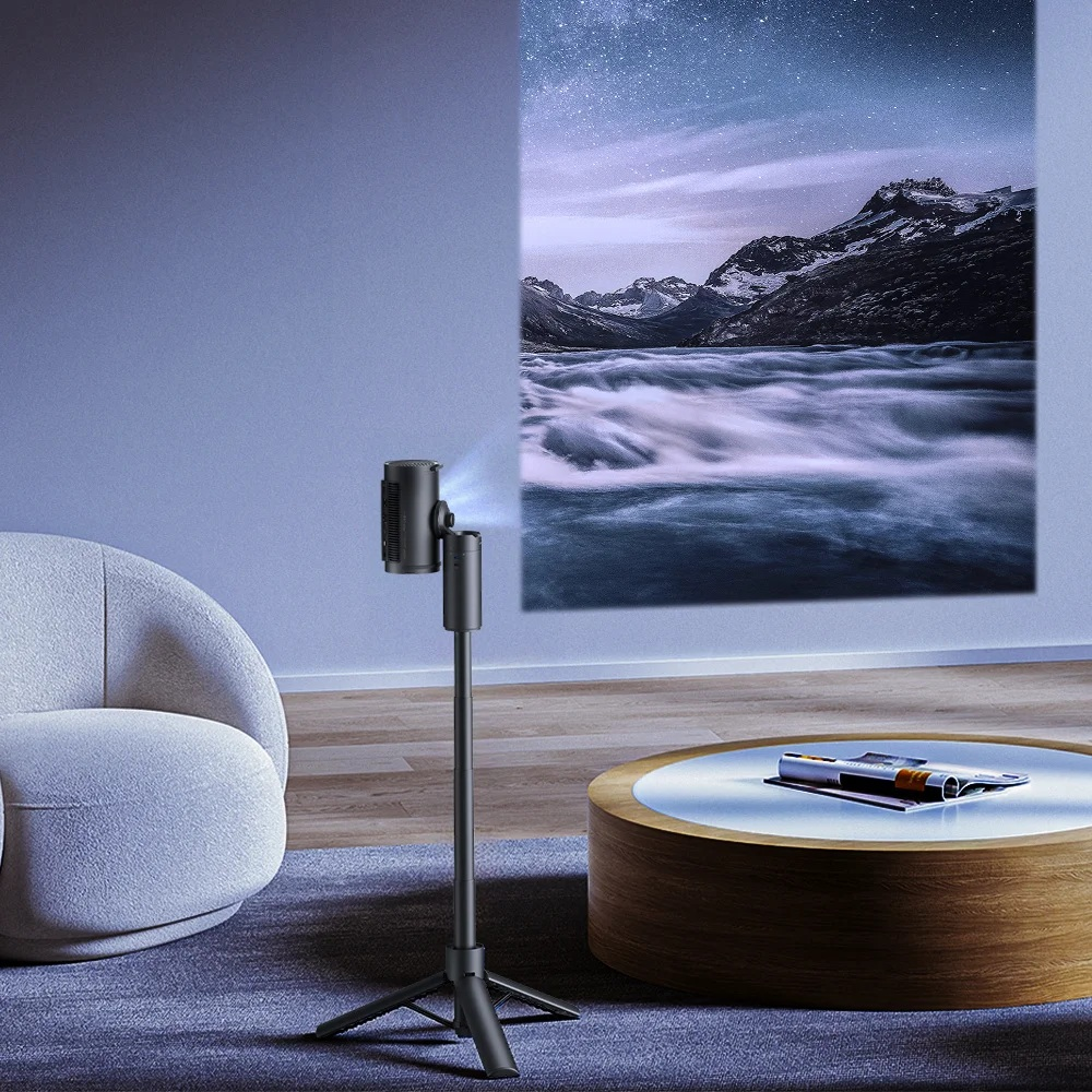 Projektor wyświetla górski krajobraz na ścianie. Okrągły stół i biały fotel na pierwszym planie.