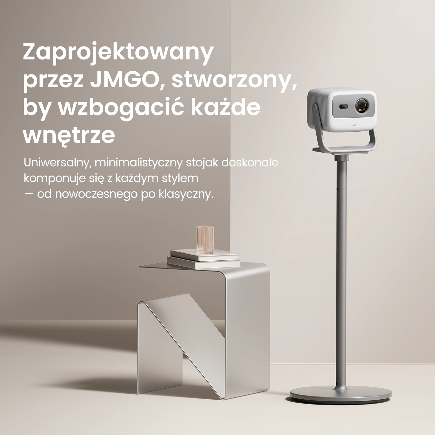Biały projektor na szarym stojaku, obok srebrnego stolika z książkami i szklanką. Widoczny tekst po polsku.