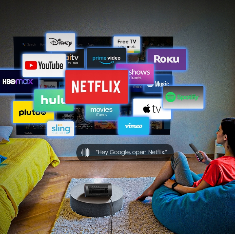 Kobieta siedzi z pilotem, oglądając usługi streamingowe na ekranie wyświetlanym na ścianie. Z przodu znajduje się projektor. Netflix jest widoczny.