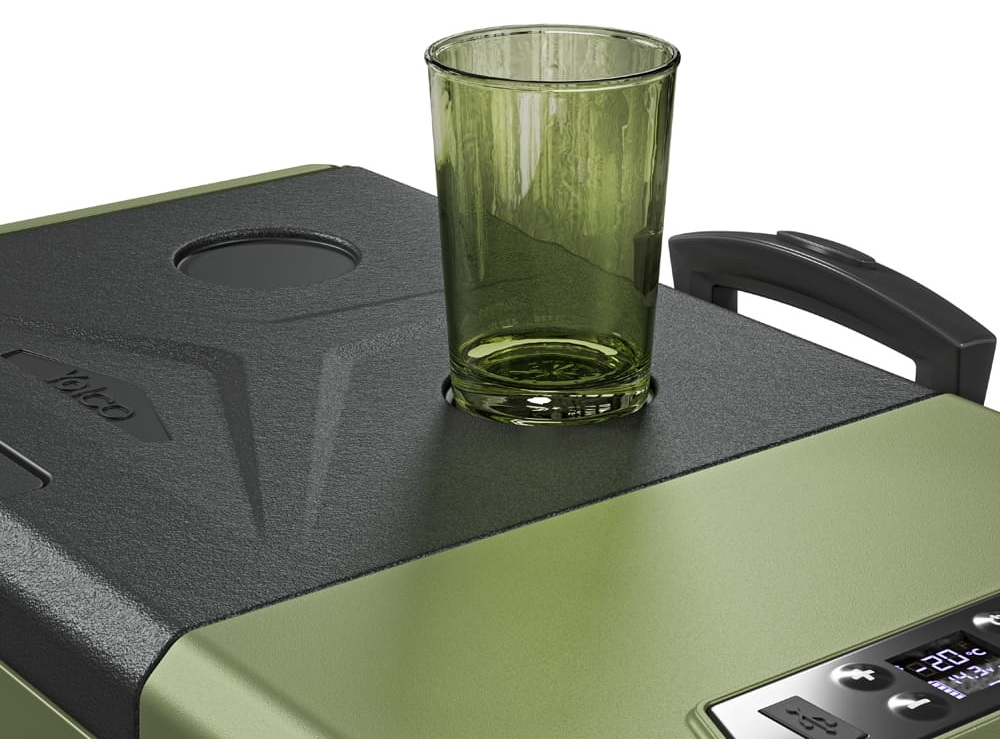 Przezroczysty zielony kieliszek stoi na pokrywie lodówki. Lodówka jest zielona z czarną pokrywą. Wyświetlacz cyfrowy pokazuje temperaturę.