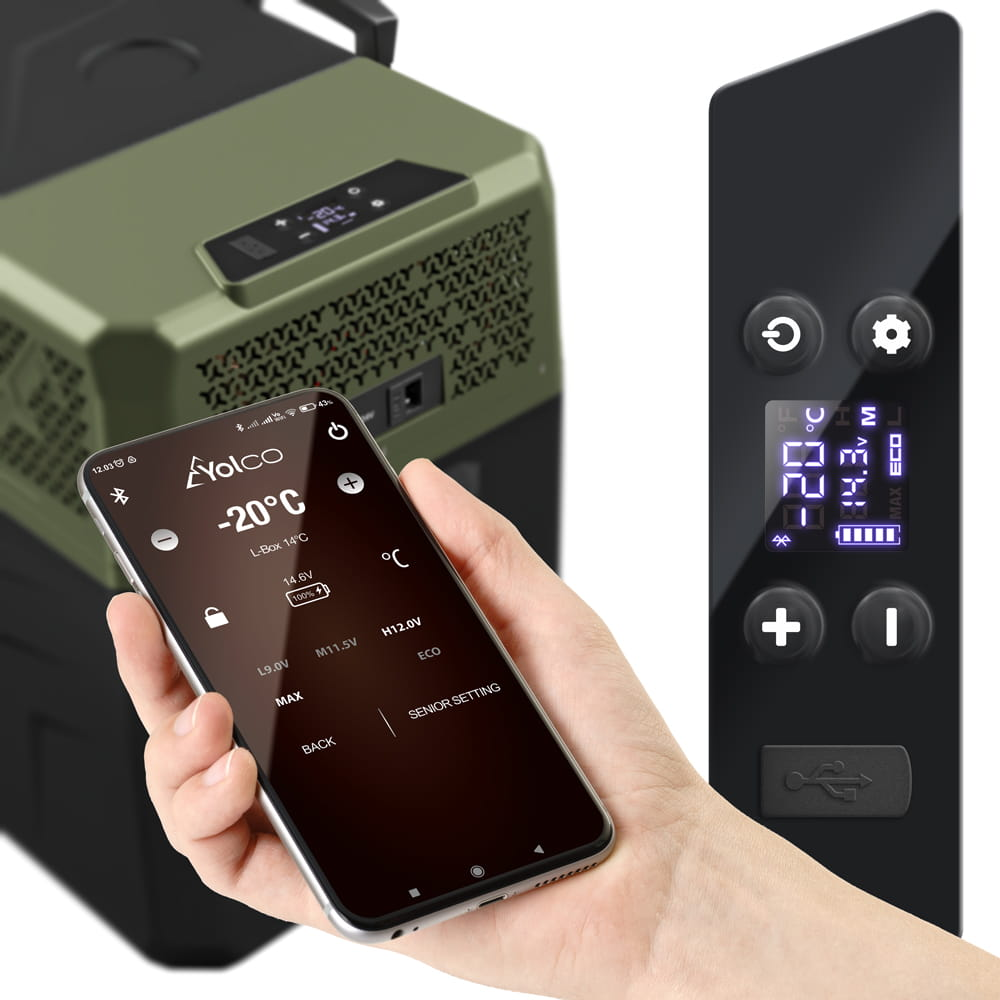 Ręka trzyma telefon z interfejsem sterowania lodówką. Widoczna jest również zielona lodówka i panel sterowania.