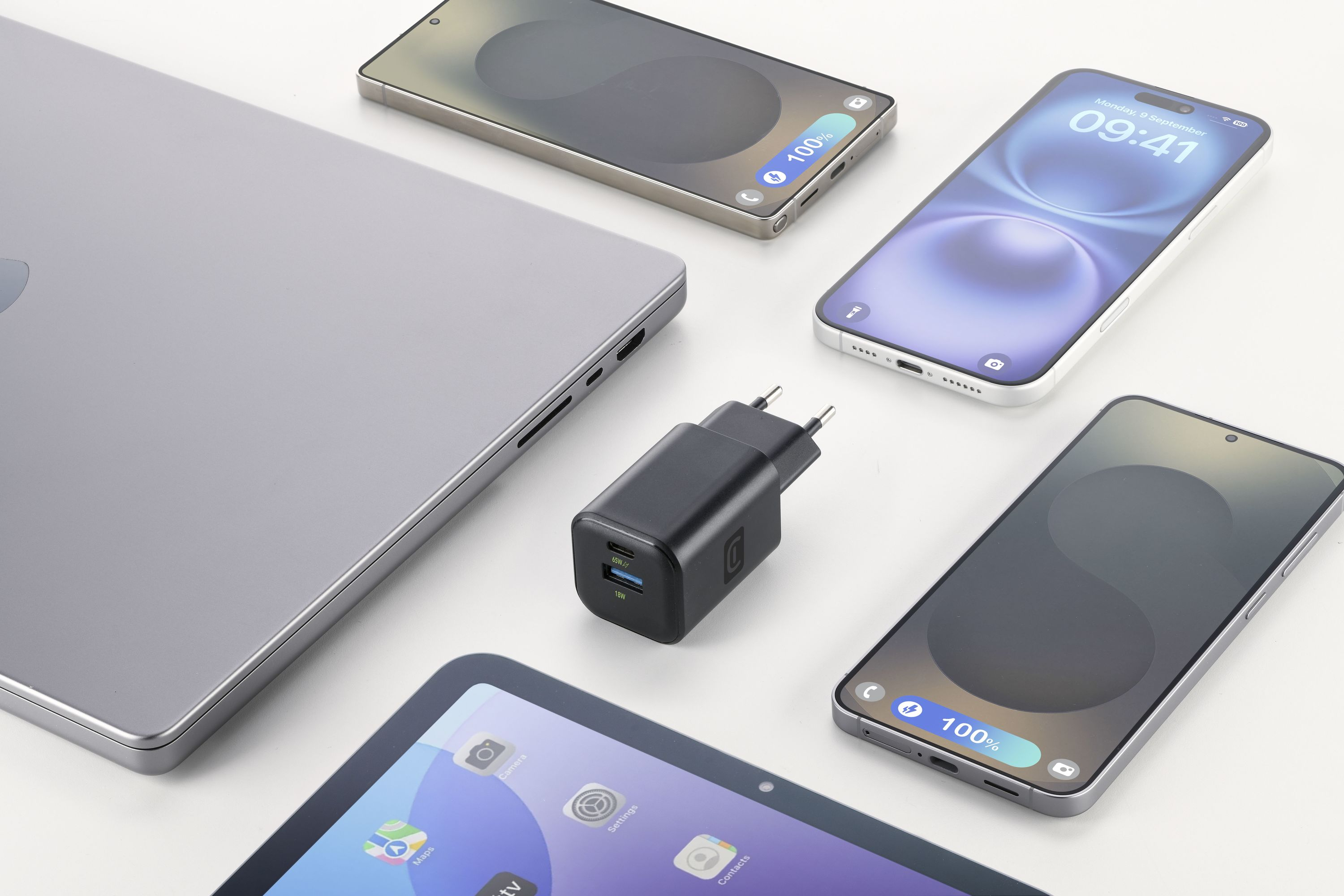 Beyaz bir yüzey üzerinde birkaç akıllı telefon, bir dizüstü bilgisayar, bir tablet ve bir şarj cihazı. Telefonlar şarj durumunu gösteriyor.