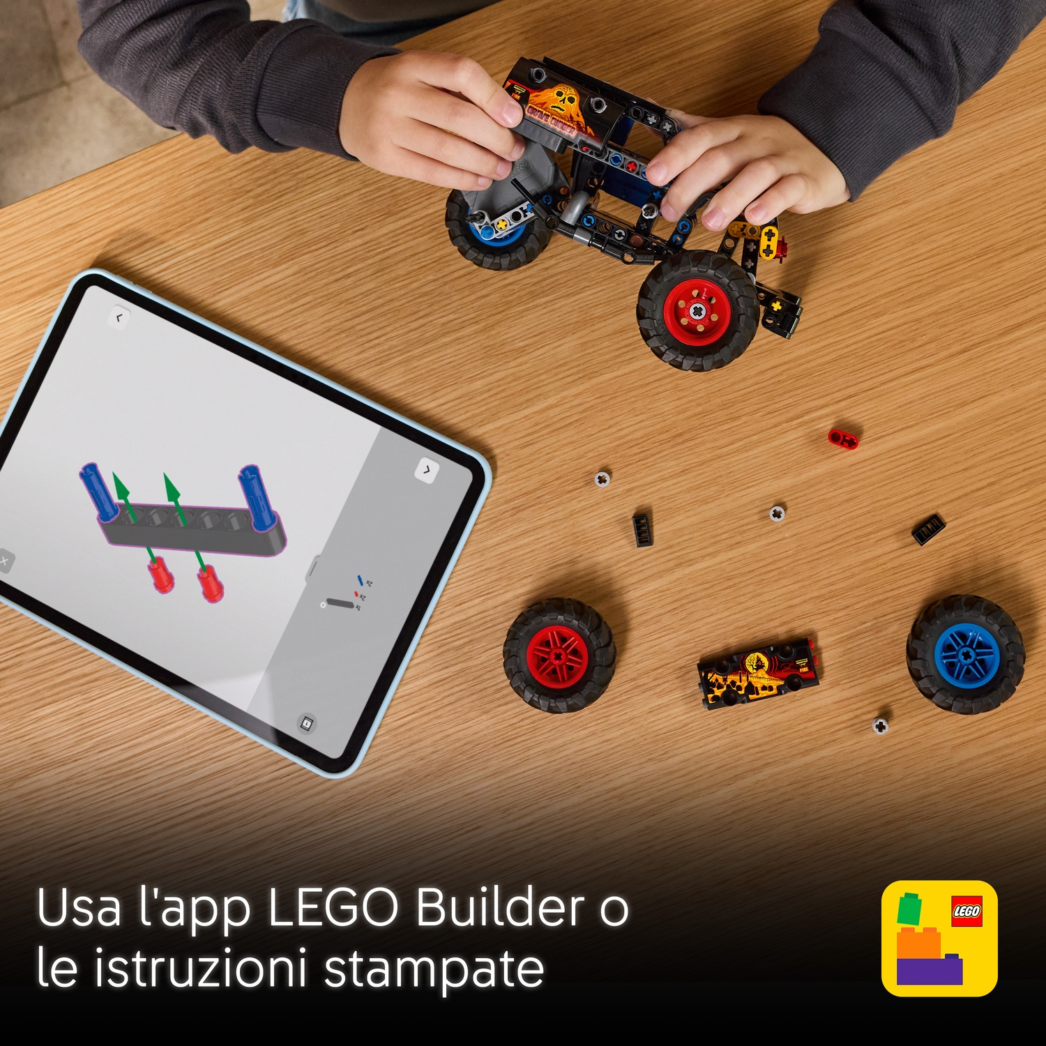 Un bambino assembla un'auto Lego su un tavolo di legno. Un tablet mostra le istruzioni. Pezzi e ruote Lego sono sparsi.