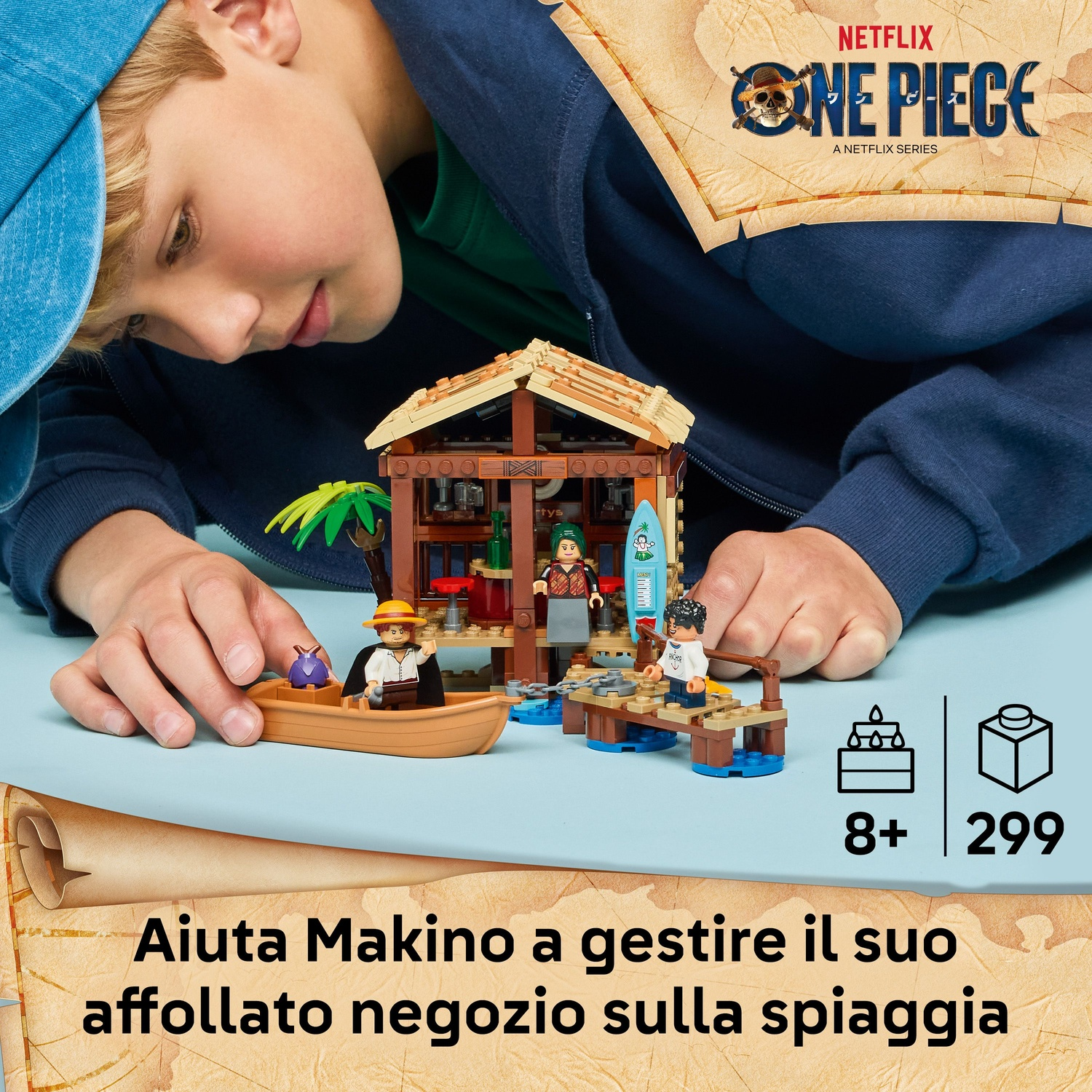 Un bambino gioca con un set Lego che rappresenta un negozio sulla spiaggia. Il set include personaggi, una barca e una tavola da surf, con il logo Netflix One Piece.