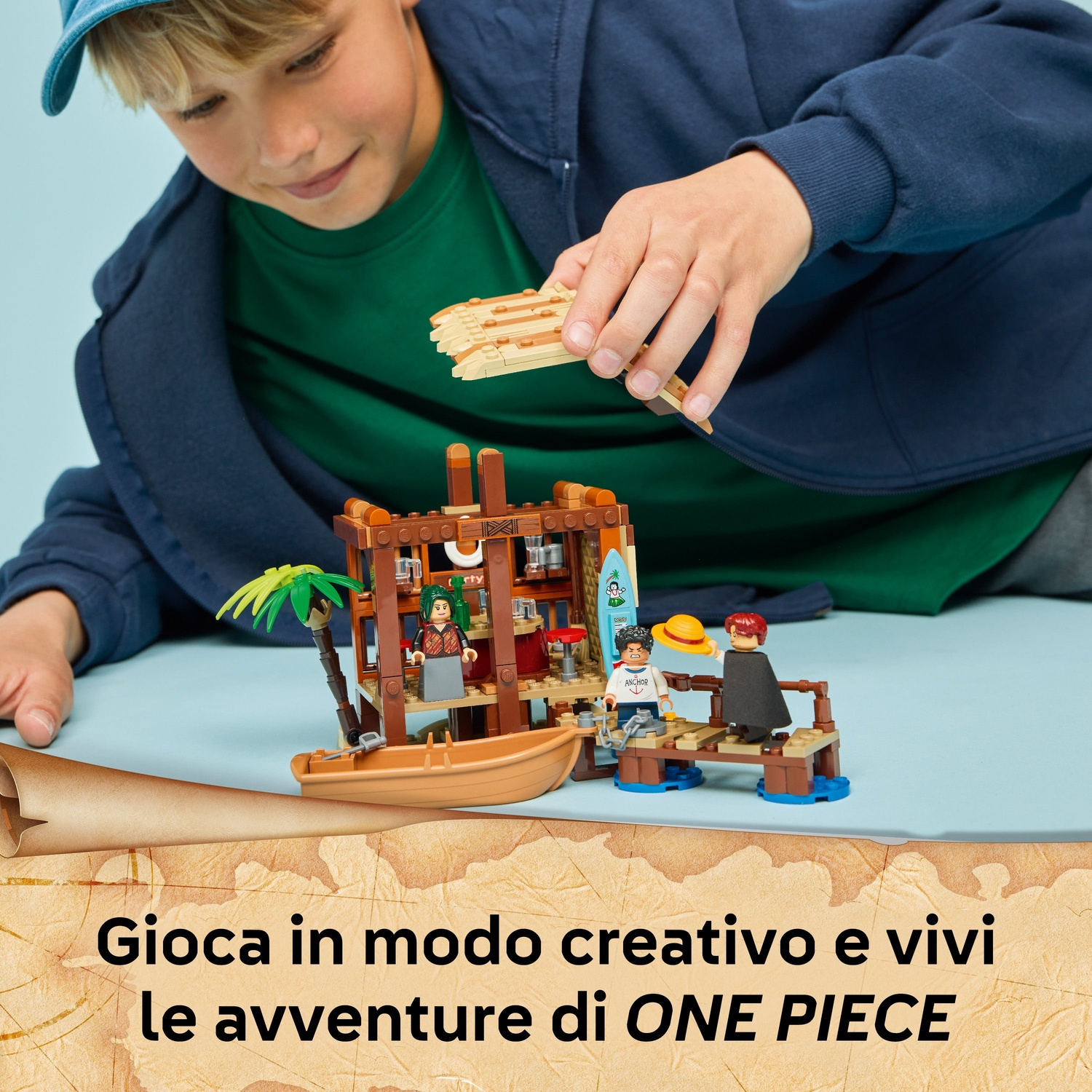 Un ragazzo gioca con un set Lego, una nave pirata. Il set include una barca, personaggi e un bar.