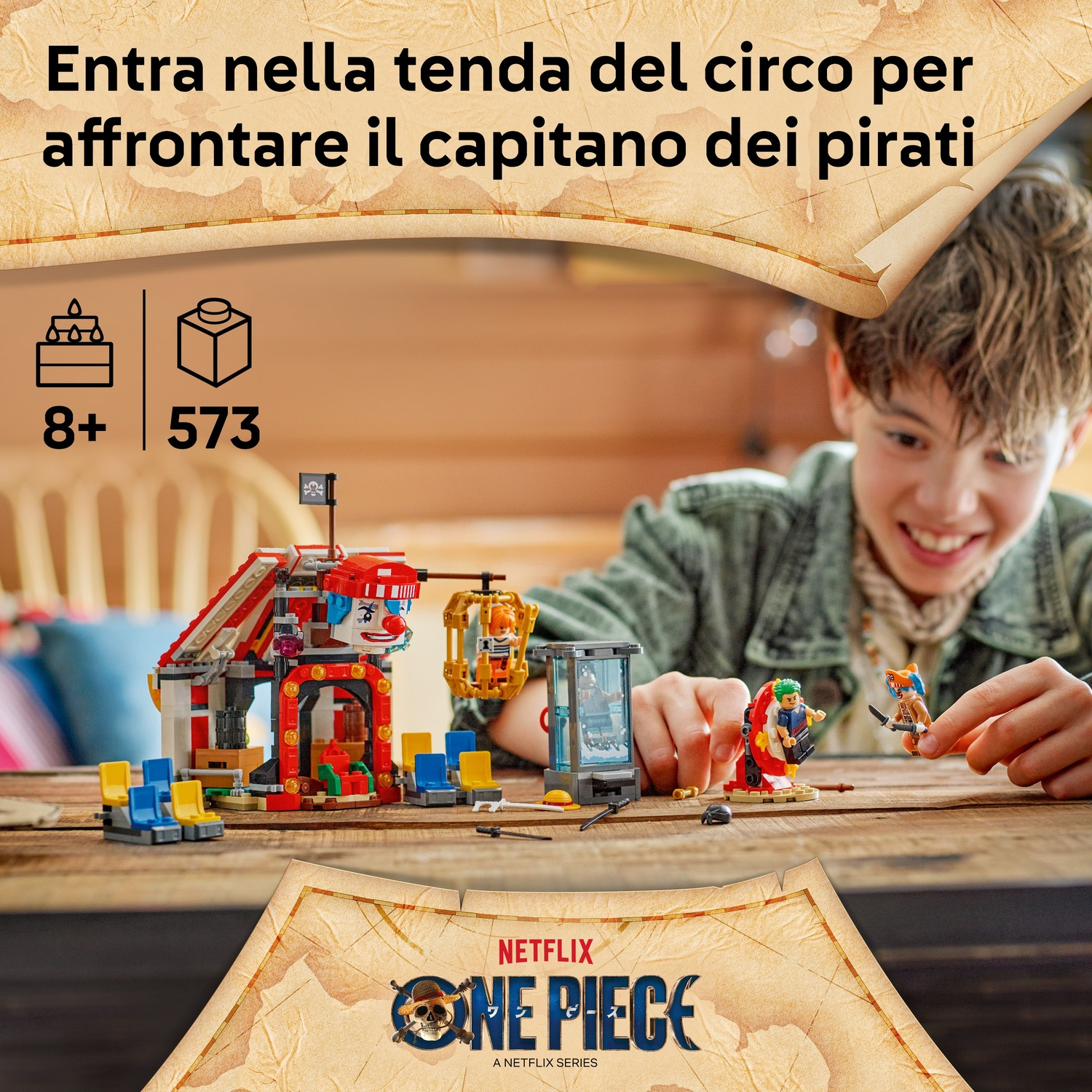 Un ragazzo sorride, gioca con un set Lego. Il set raffigura un circo con personaggi pirata. Il testo dice: 'Entra nel tendone del circo...'