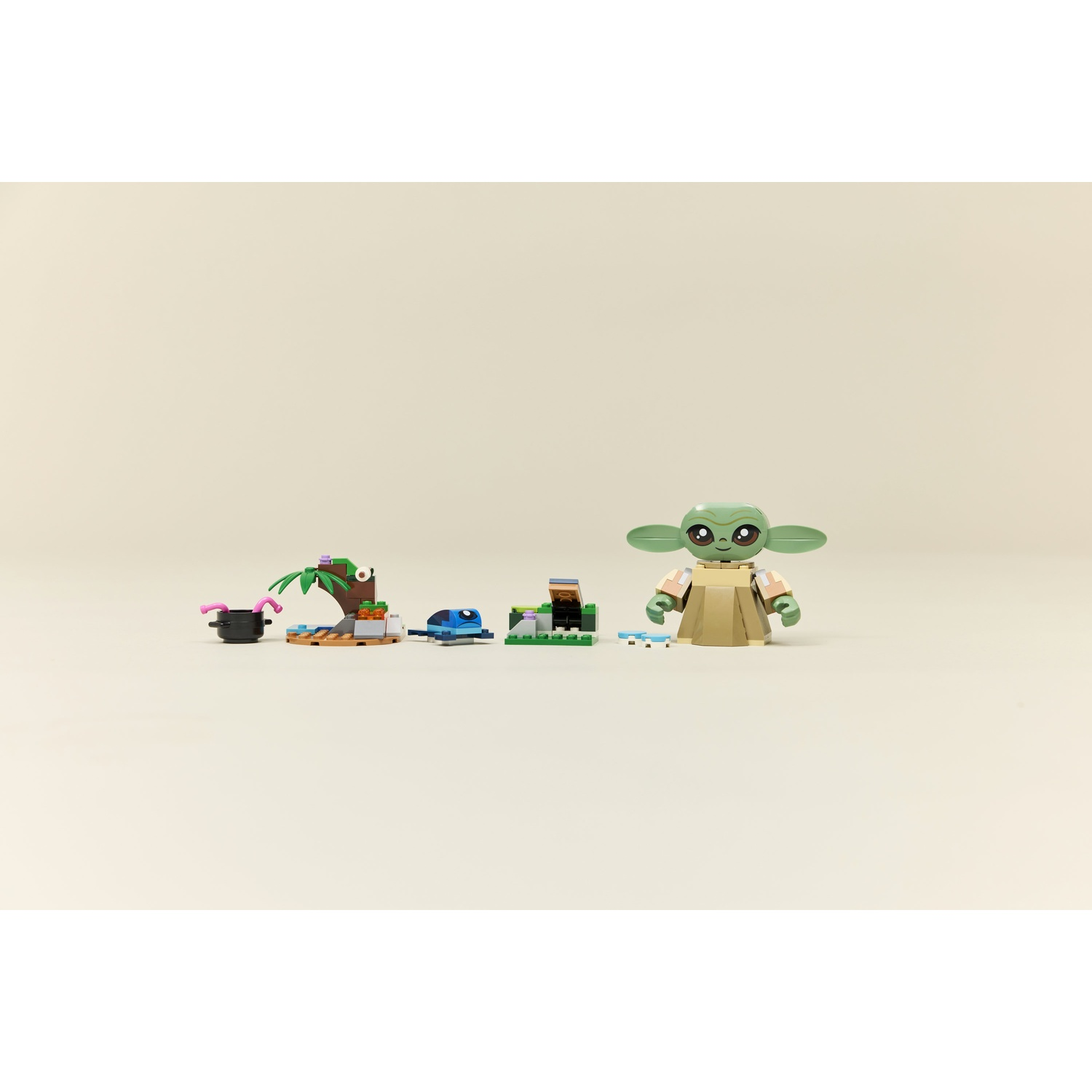 Un set Lego con Baby Yoda e diverse piccole costruzioni. Include un vaso nero, una palma, un veicolo blu e altre strutture miniaturizzate.