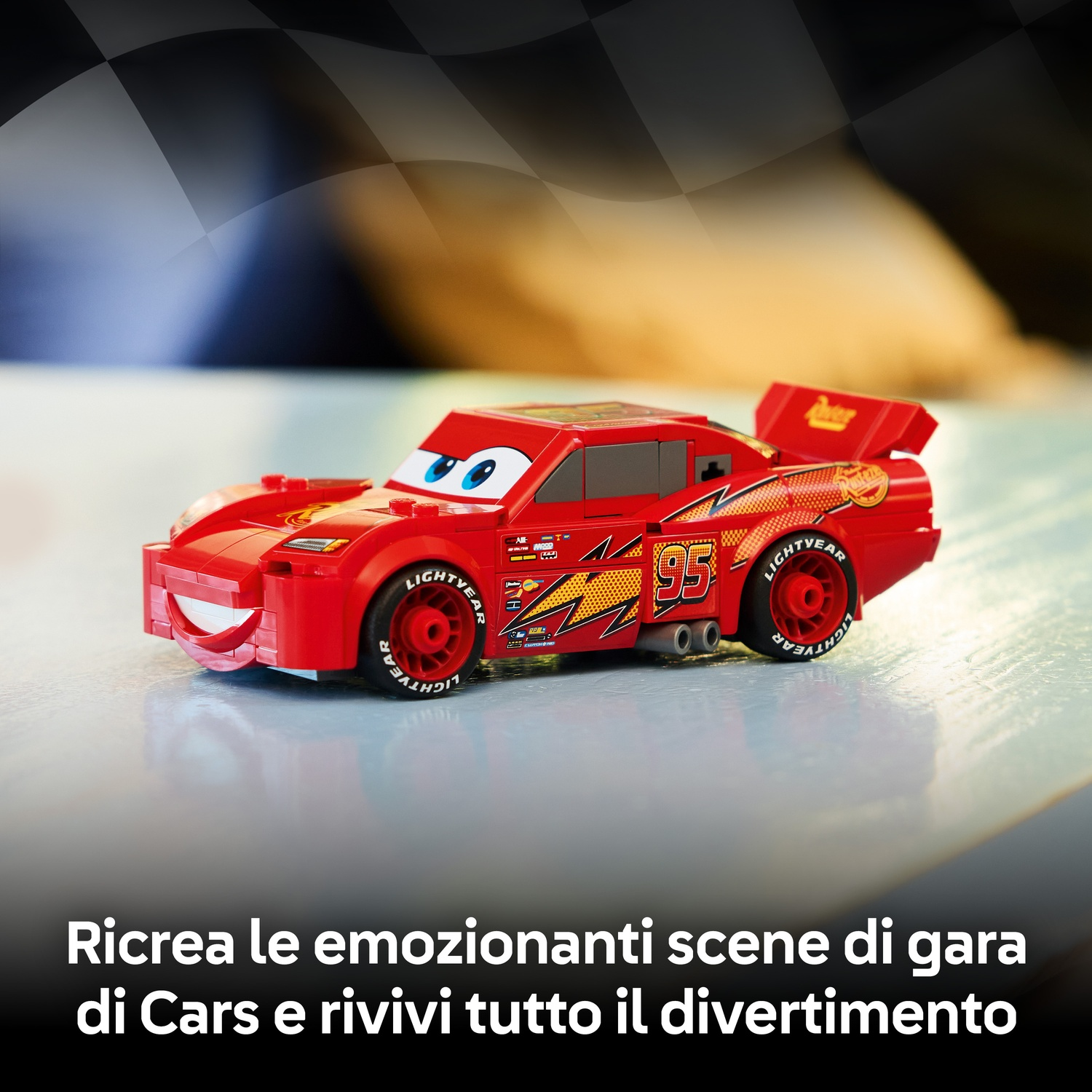 Un'auto Lego rossa di Lightning McQueen con dettagli neri e gialli. Ha il numero 95. Lo sfondo presenta una bandiera a scacchi e del testo.