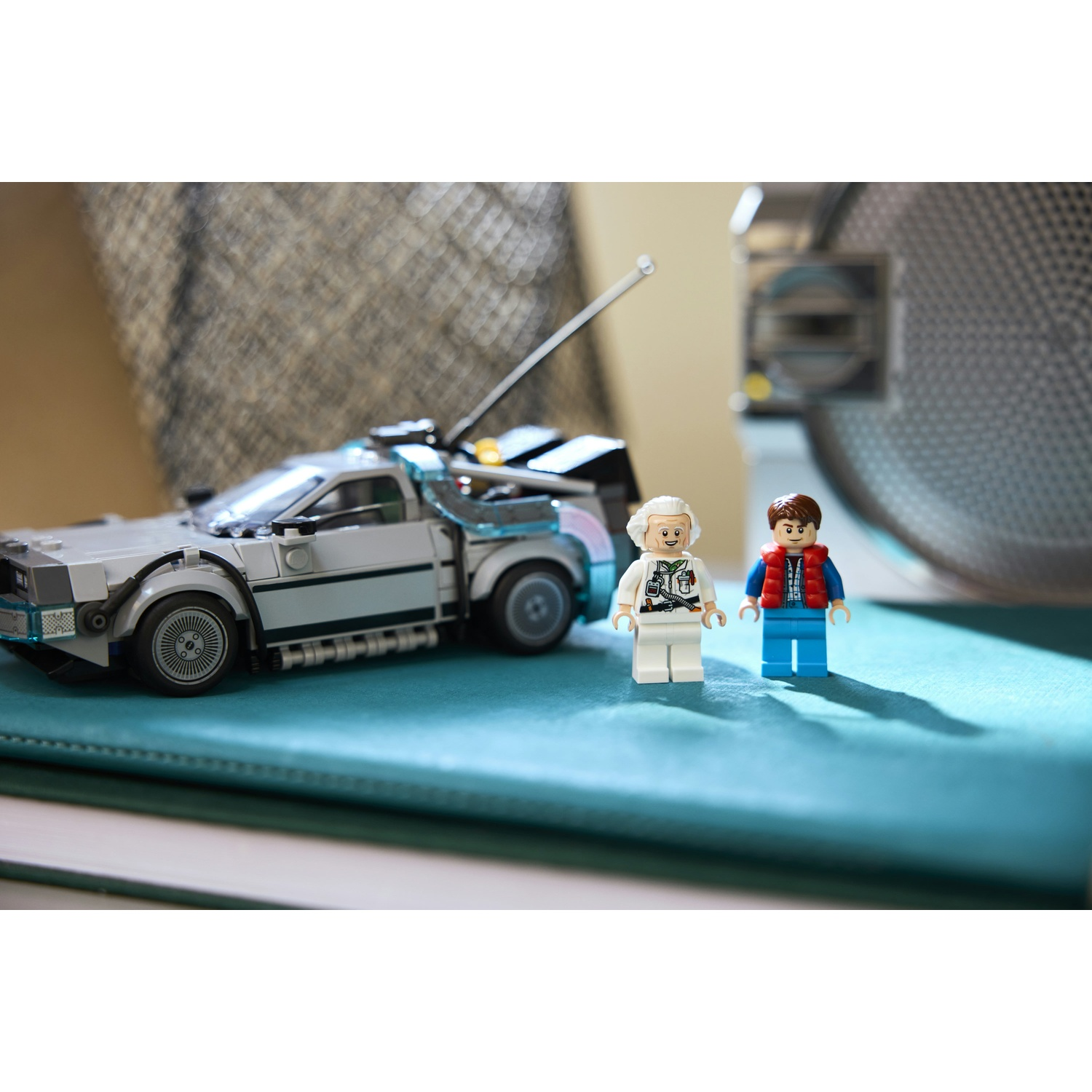 Set Lego della macchina del tempo DeLorean con i personaggi di Doc Brown e Marty McFly. L'auto è grigia, personaggi su superficie blu.
