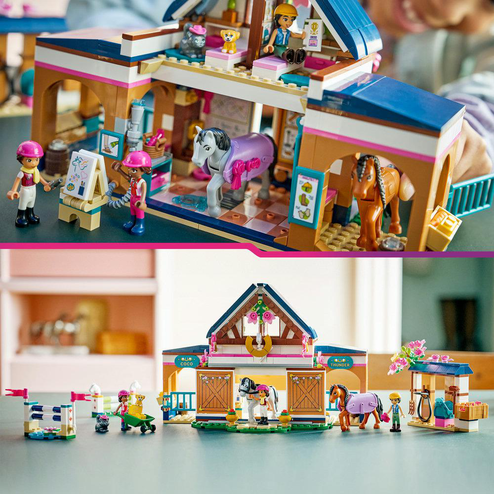 Lego-Pferdestall mit Figuren und Pferden. Rosa- und Brauntöne. Figuren interagieren mit Pferden und Umgebung.