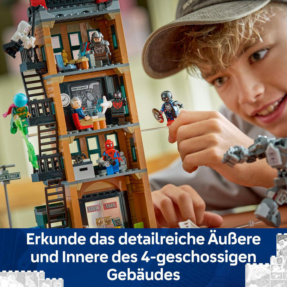 Ein Junge hält eine Captain America Lego-Figur. Ein mehrstöckiges Lego-Gebäude hat verschiedene Superhelden-Figuren innen und außen.