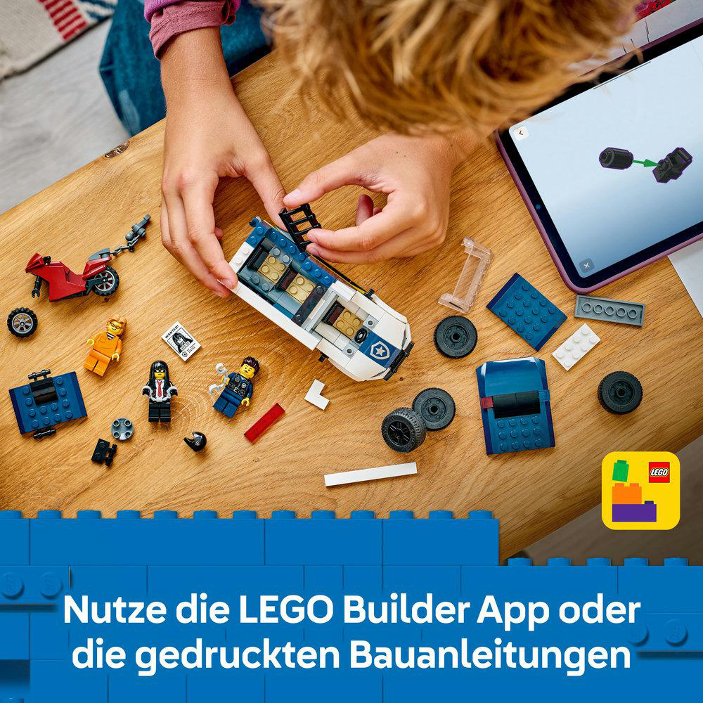 Eine Person baut ein LEGO-Set auf einem Holztisch. Es gibt ein weißes und blaues Auto, ein rotes Motorrad und verschiedene LEGO-Figuren.