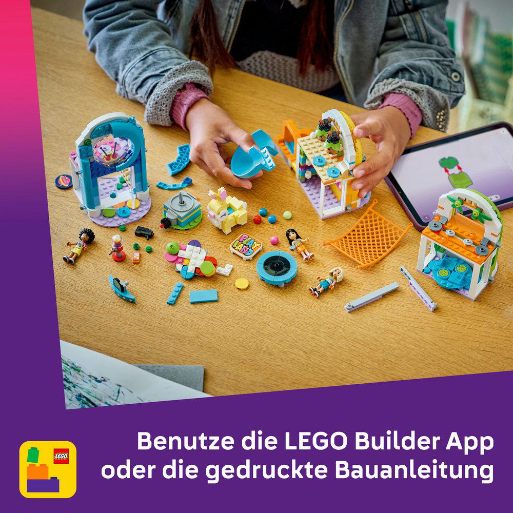 Hände bauen LEGO-Sets auf einem Holztisch zusammen. Verschiedene LEGO-Teile und kleine Figuren sind um die Sets verstreut.