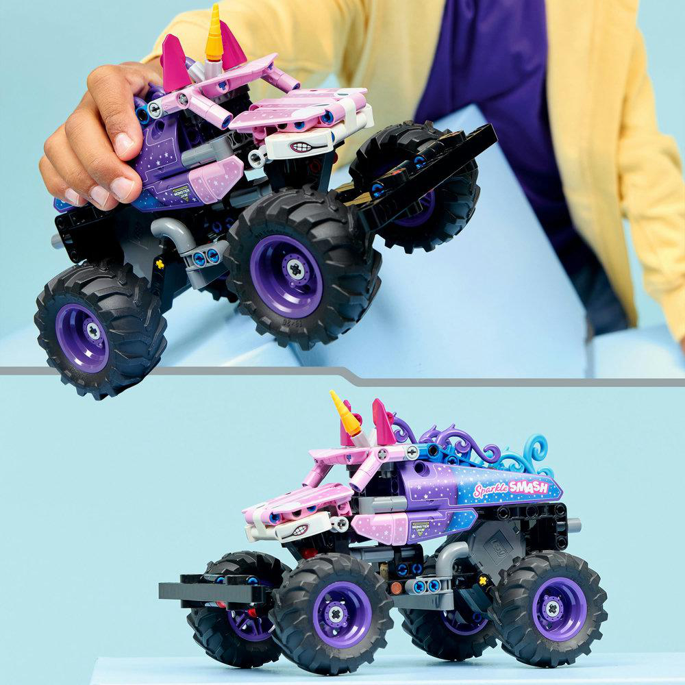 Eine Person hält einen Spielzeug-Monster-Truck. Es ist lila und rosa, mit großen Rädern und einem Einhorn-Design. Der Hintergrund ist ein gelbes Hemd.