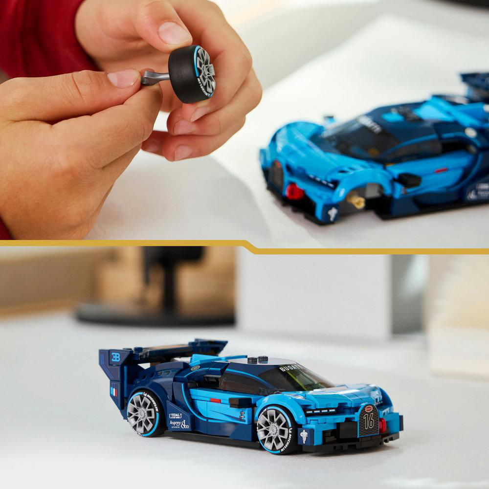 Hände halten ein Spielzeugautorad und ein blaues Spielzeugauto. Das Auto steht auf einer weißen Oberfläche, zusammengebaut. Das Rad ist in der Nähe des Autos.