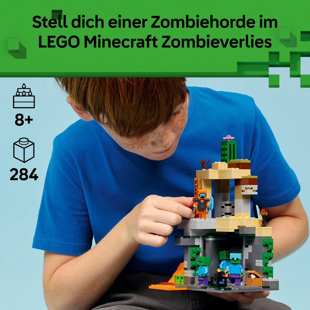 Ein Junge hält ein LEGO Minecraft-Set mit Zombies. Das Set enthält eine Höhle, Figuren und ist für Kinder ab 8 Jahren geeignet. Der Hintergrund ist blau.