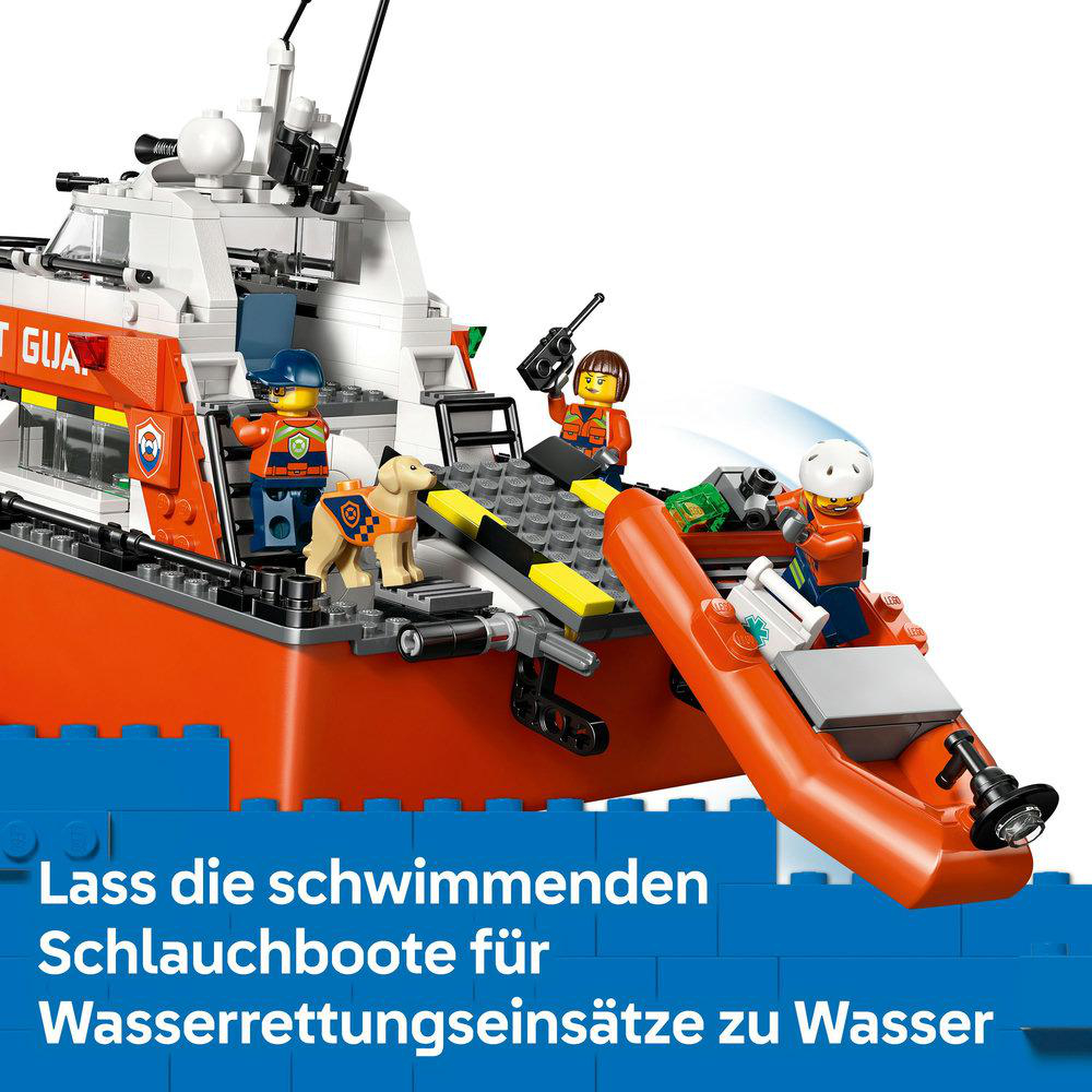 Ein Lego-Rettungsboot mit Minifiguren und einem Hund. Ein orangefarbenes Schlauchboot ist im Wasser. Das Boot ist in einem Hafen.