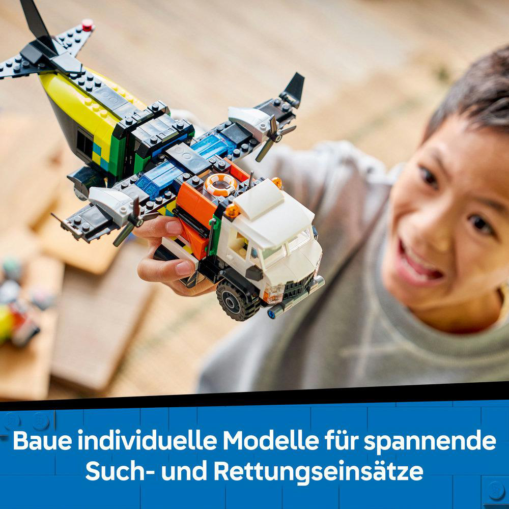 Ein Kind hält ein LEGO-Modell eines Flugzeugs und eines Lastwagens. Das Flugzeug hat gelbe, schwarze und weiße Farben. Das Kind lächelt.