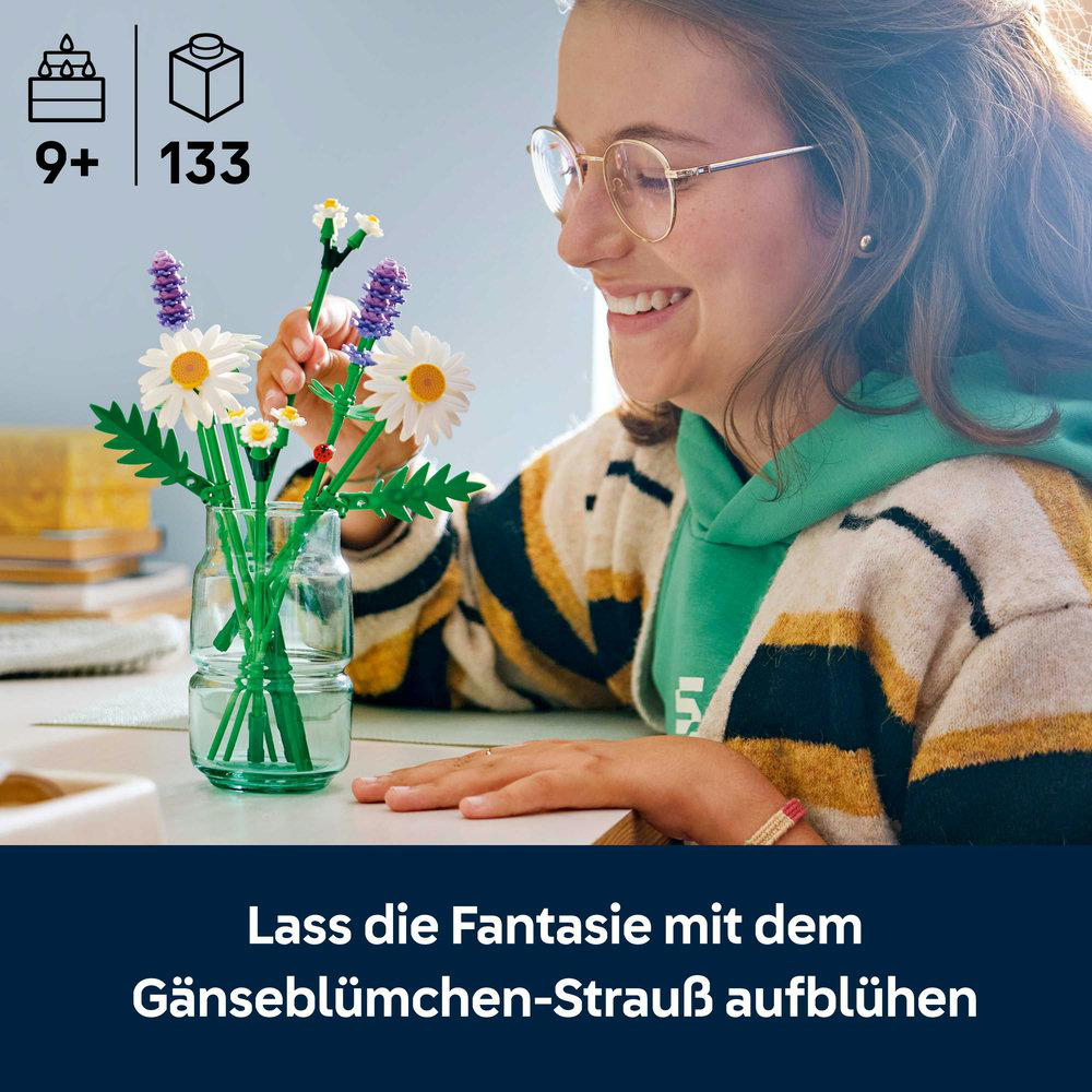 Eine lächelnde Frau hält einen LEGO-Gänseblümchen-Strauß. Das Set ist für Kinder ab 9 Jahren und enthält 133 Teile. Der Hintergrund ist unscharf.