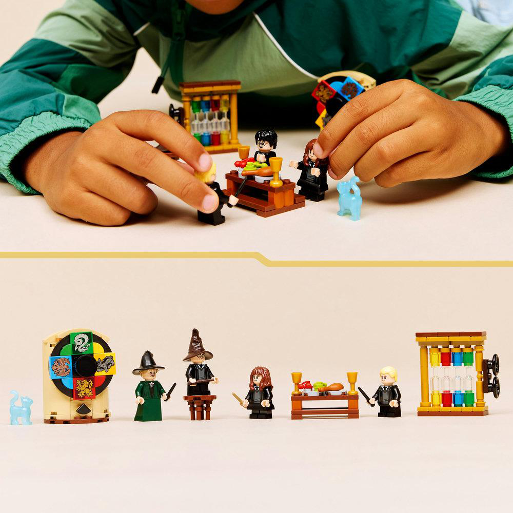 Kinderhände interagieren mit Lego-Figuren und -Sets. Das Bild zeigt verschiedene Harry-Potter-Themen-Lego-Minifiguren und -Strukturen.