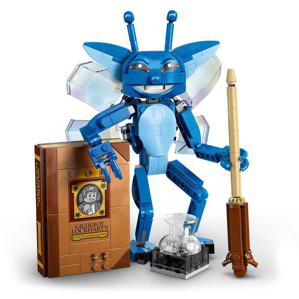 Eine blaue Lego-Figur mit Flügeln, die einen Zauberstab hält. Sie steht neben einem Buch und einer klaren Flasche auf schwarzem Grund.
