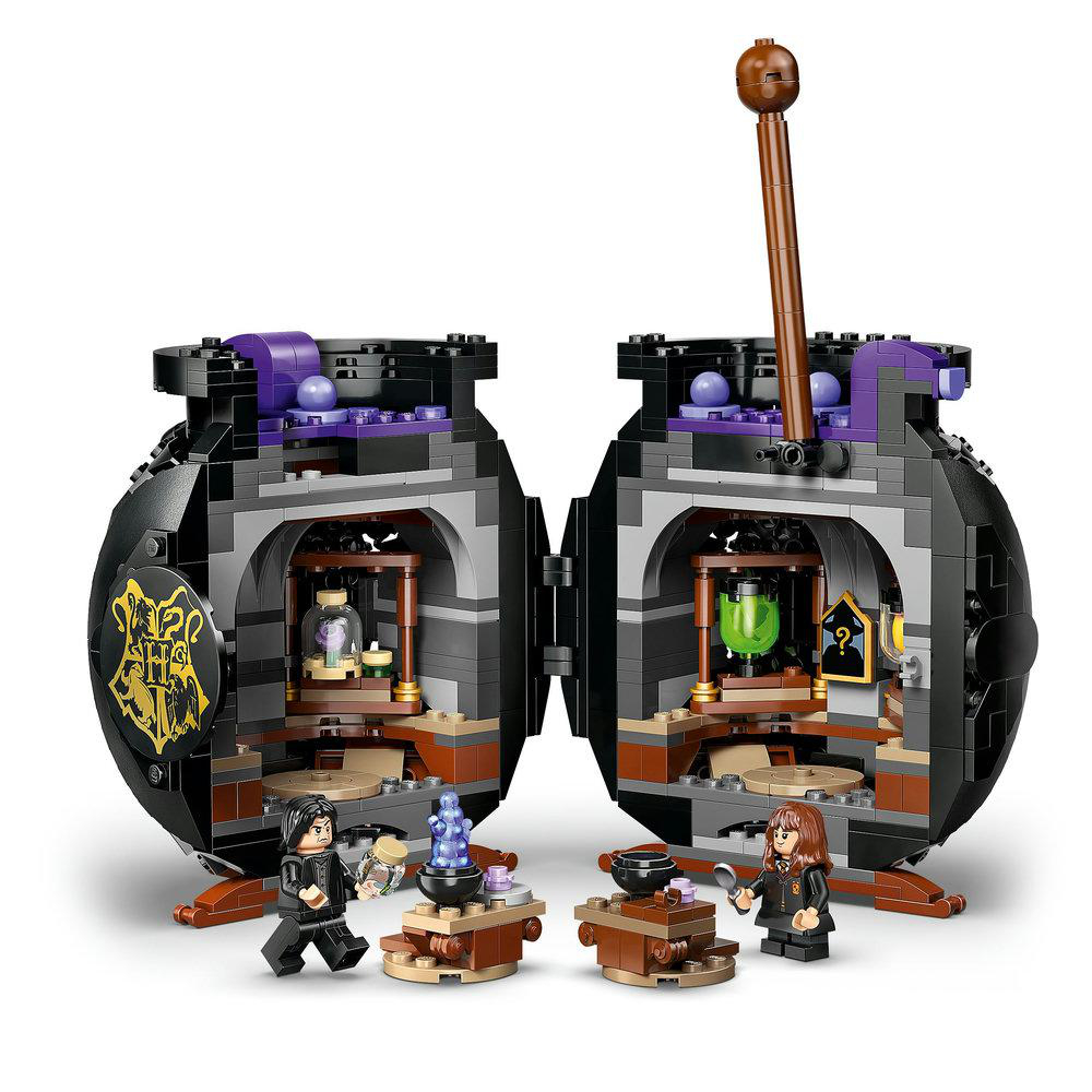 Ein Lego-Set mit zwei Kesseln. Im Inneren befinden sich verschiedene Gegenstände und Figuren. Zwei Figuren stehen in der Nähe mit kleinen Tischen.