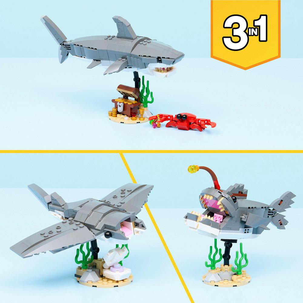 Das Bild zeigt drei Lego-Hai-Modelle, eine Schatzkiste, eine Krabbe und einen Fisch mit Licht. Oben rechts befindet sich ein Logo mit '3 in 1'.