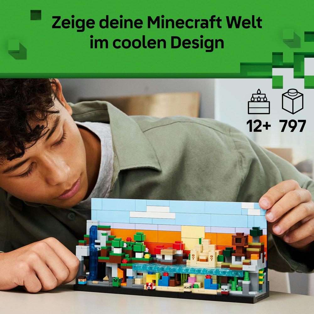 Eine Person hält ein Minecraft LEGO-Set. Das Set zeigt eine Minecraft-Szene mit verschiedenen Strukturen und Blöcken. Grüner Text oben.