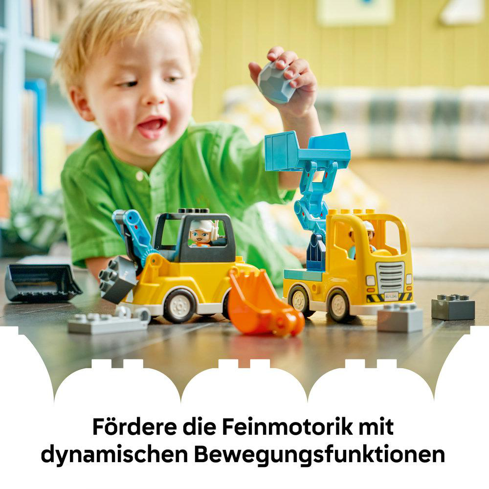Ein Kind spielt mit Spielzeug-Baufahrzeugen. Gelbe Lastwagen und ein grauer Stein stehen im Fokus. Das Kind trägt ein grünes Hemd.