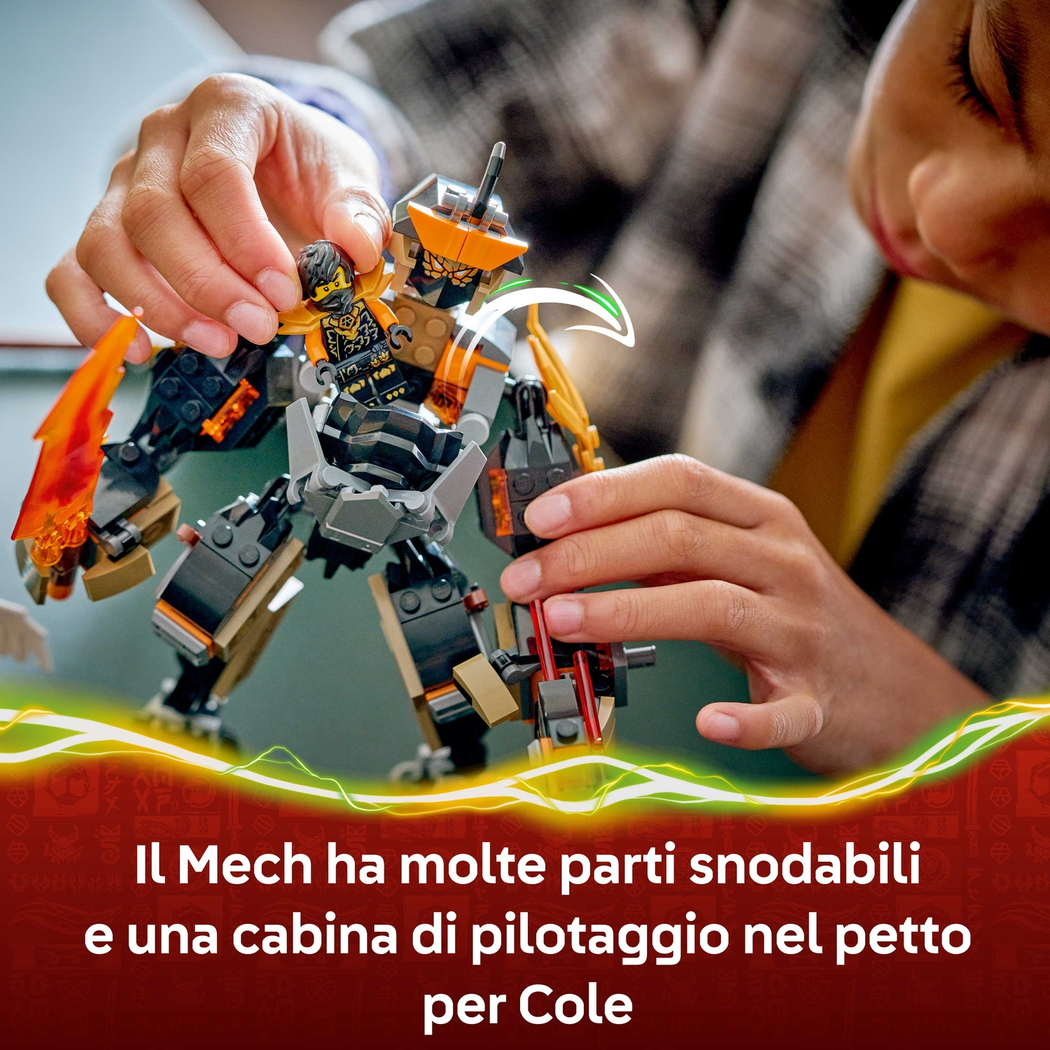 Una persona gioca con un mech Lego. Il mech è nero, arancione e grigio. Una piccola figura Lego è tenuta dalla persona.