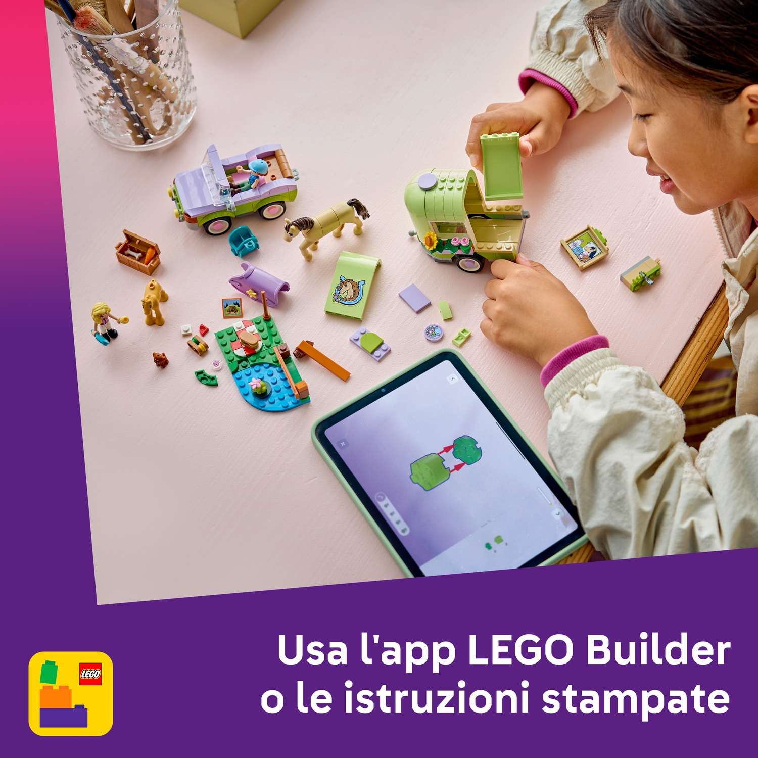 Una bambina gioca con set Lego su un tavolo rosa. C'è un camper, una jeep e vari piccoli pezzi Lego. Un tablet mostra le istruzioni.