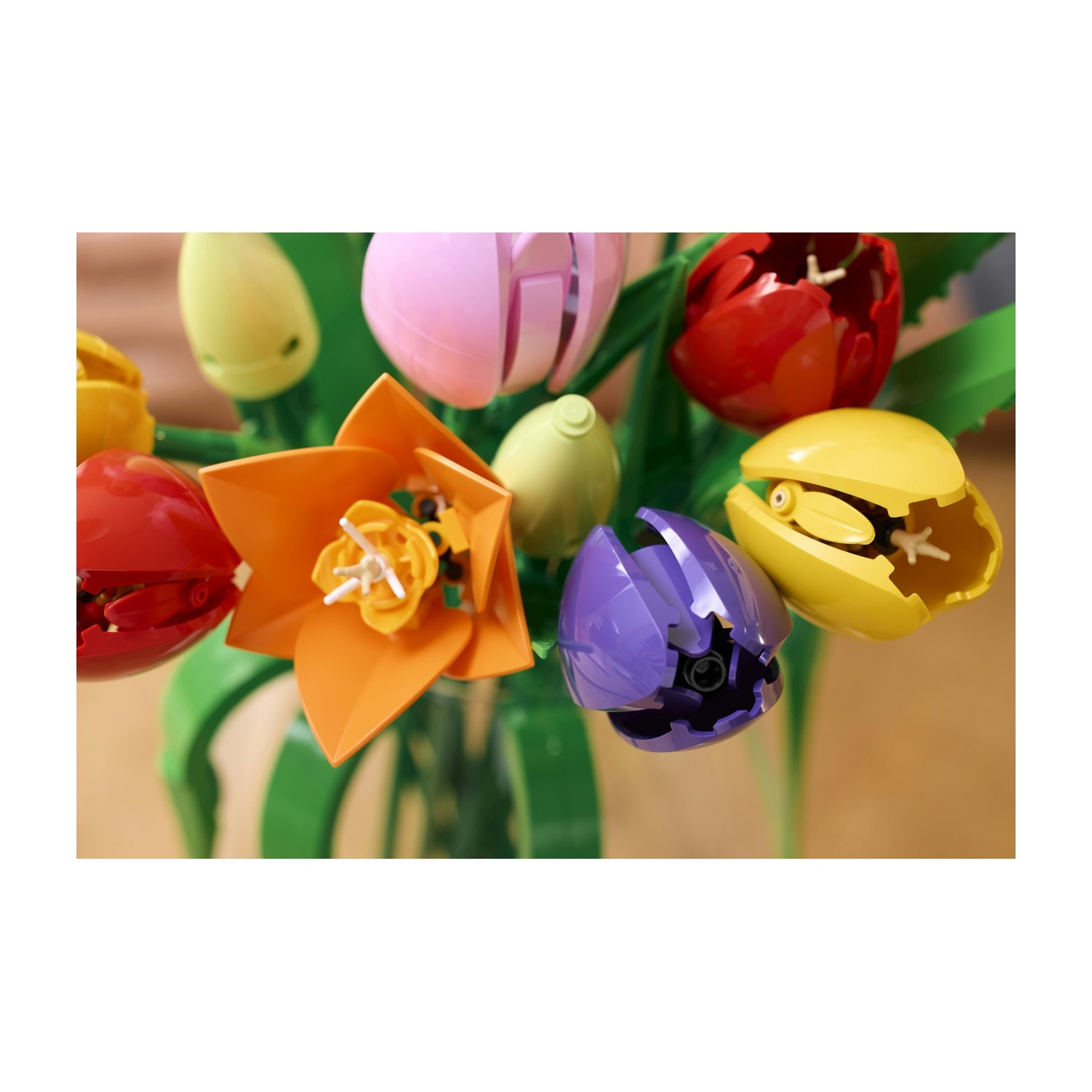 Un bouquet di tulipani Lego in vari colori, tra cui rosso, giallo, rosa, arancione e viola, con steli verdi, in un vaso.