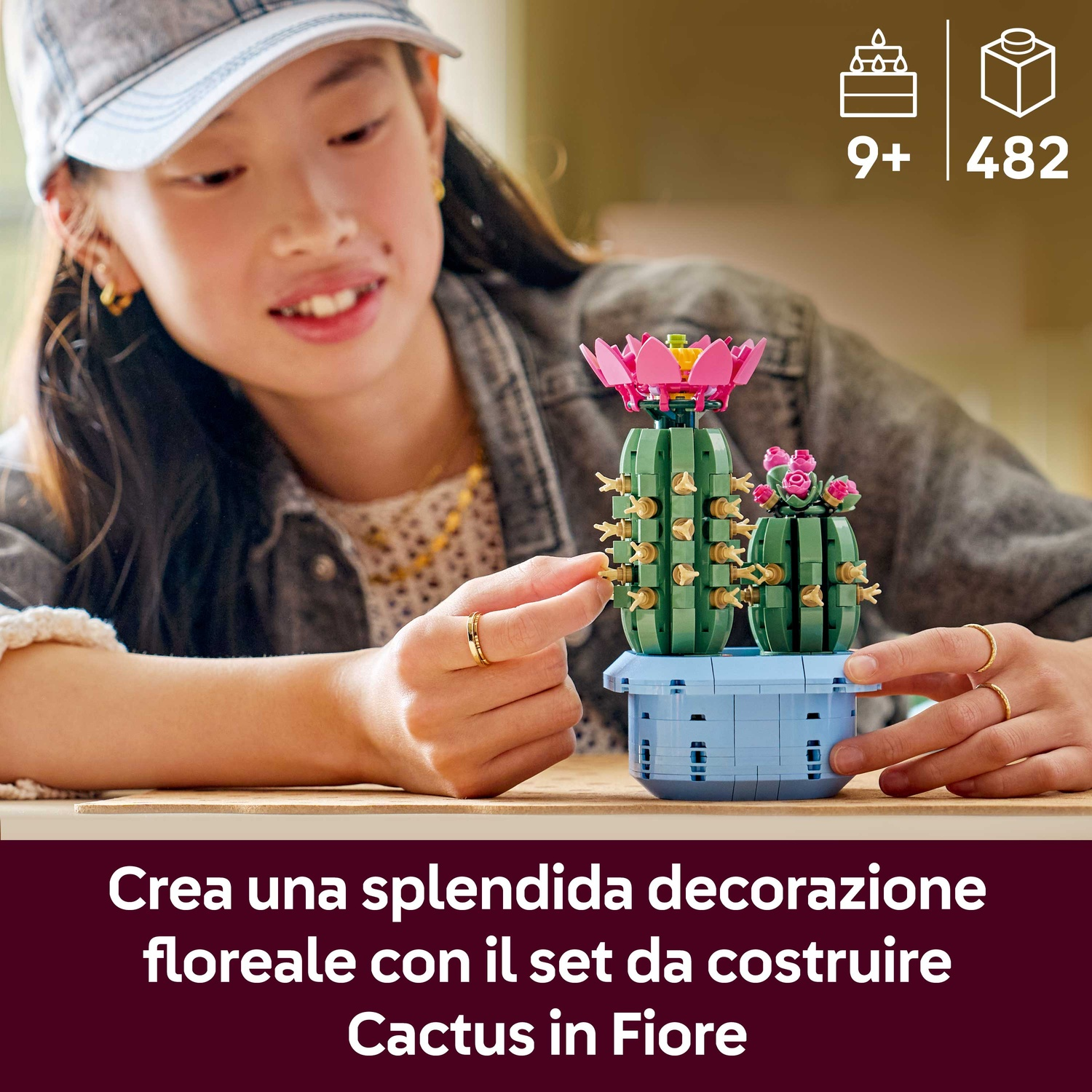 Una ragazza costruisce un set di cactus Lego. Il set include due cactus in un vaso blu. Un cactus ha un fiore rosa.