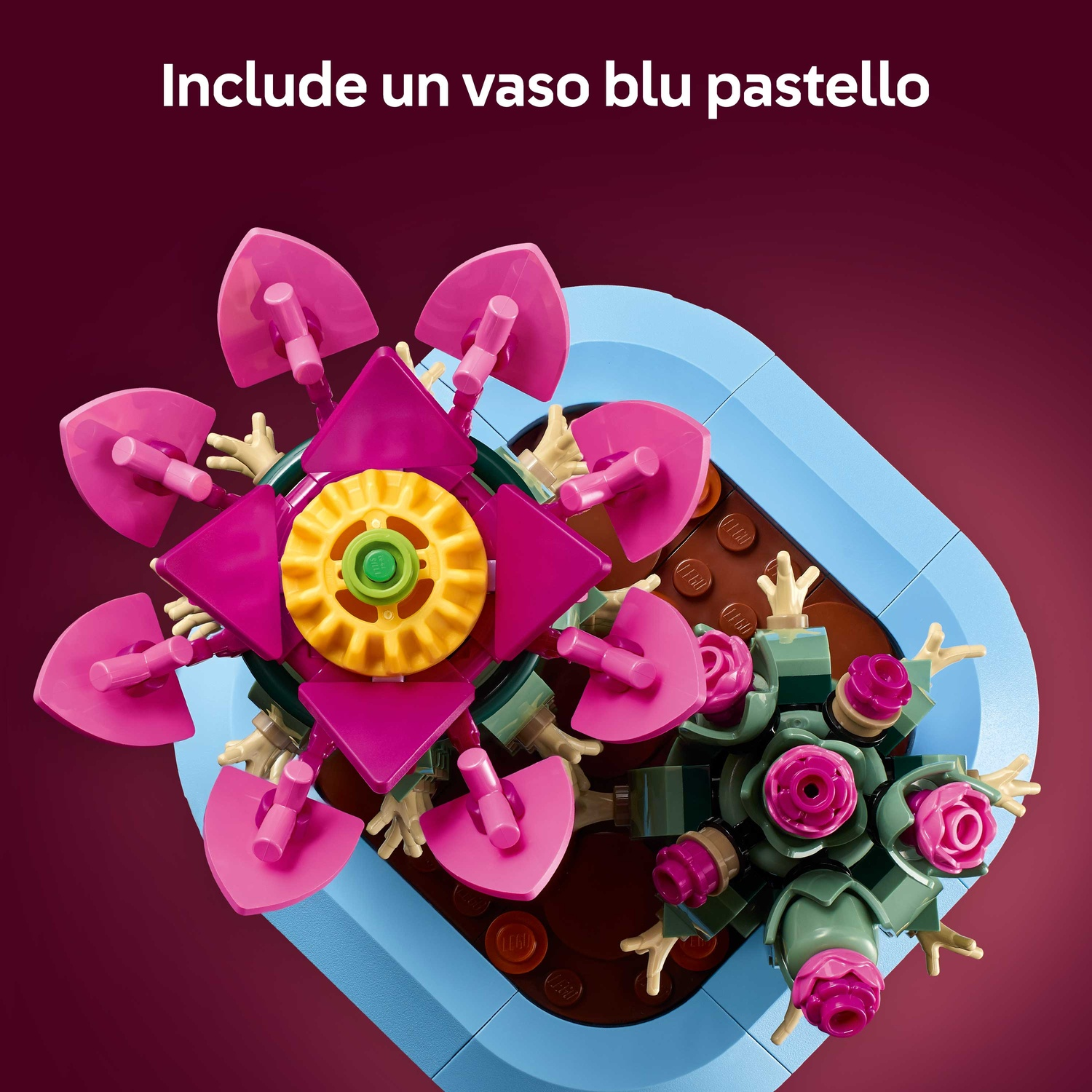 Una composizione floreale Lego con petali rosa, centro giallo e steli verdi in un contenitore azzurro, su sfondo bordeaux.