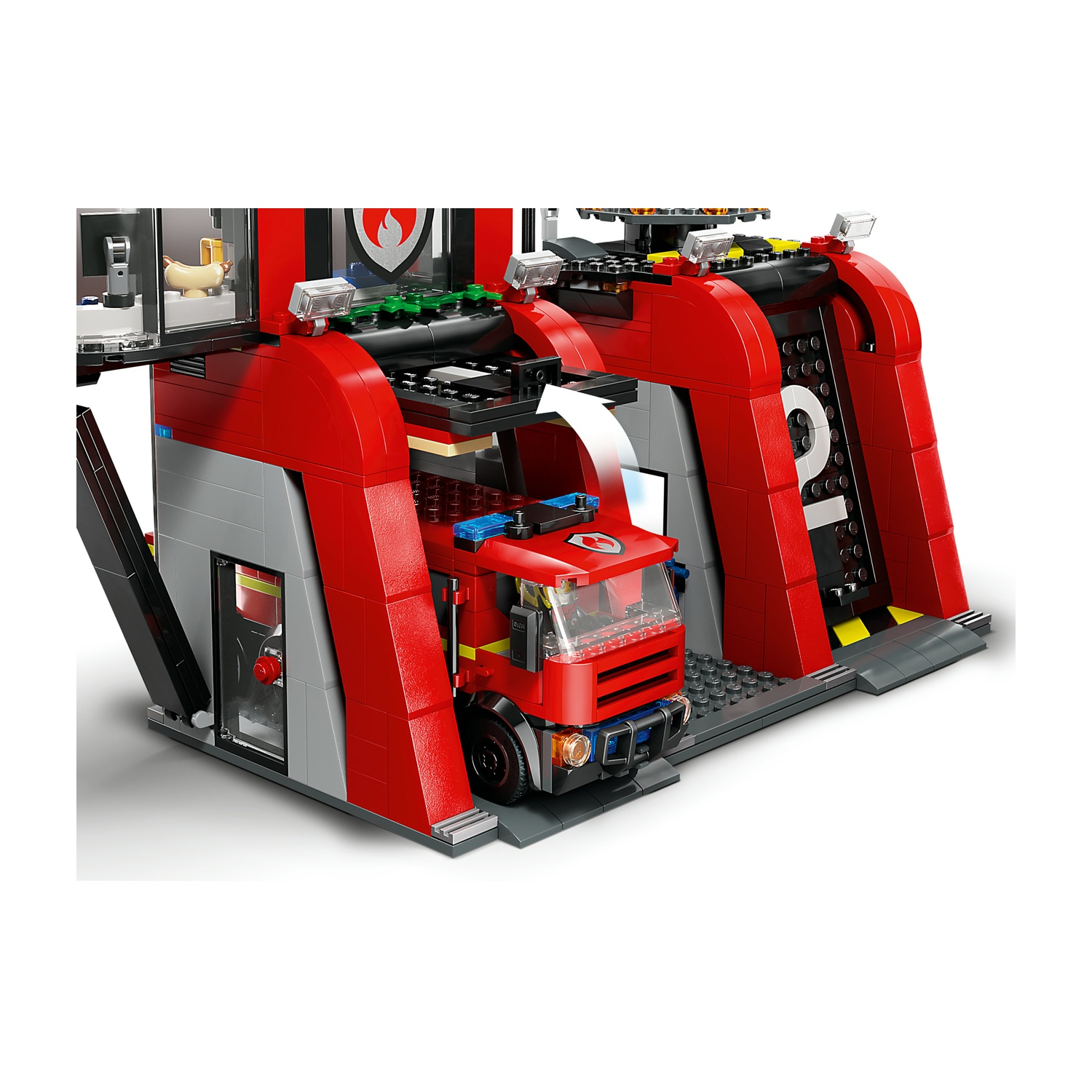 Una caserma dei pompieri Lego con un camion dei pompieri rosso all'interno. La stazione è rossa e grigia. Un hot dog è visibile.