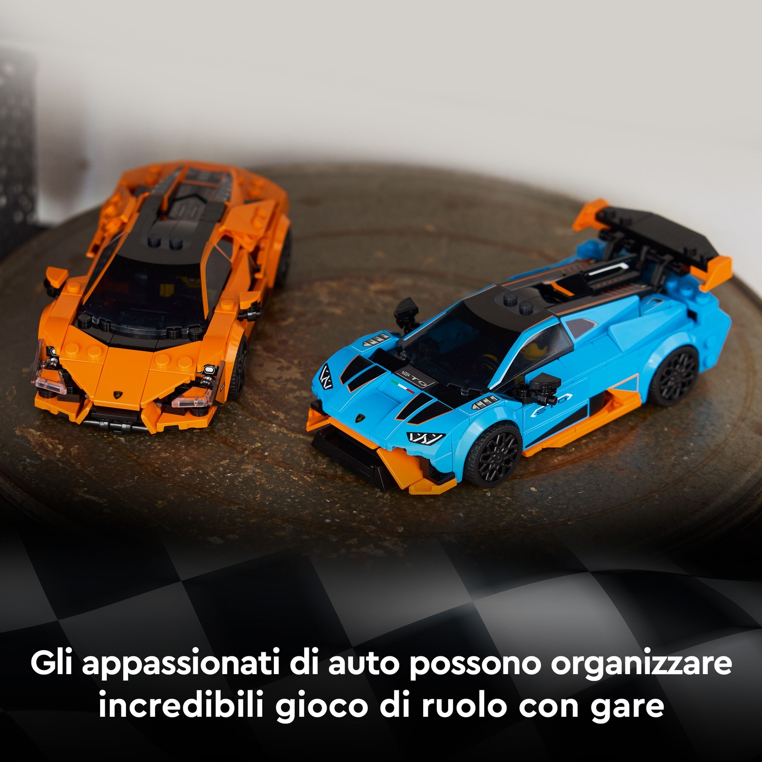 Due macchinine da corsa giocattolo, una arancione e una blu, su una superficie strutturata. Le auto sono dettagliate e pronte.