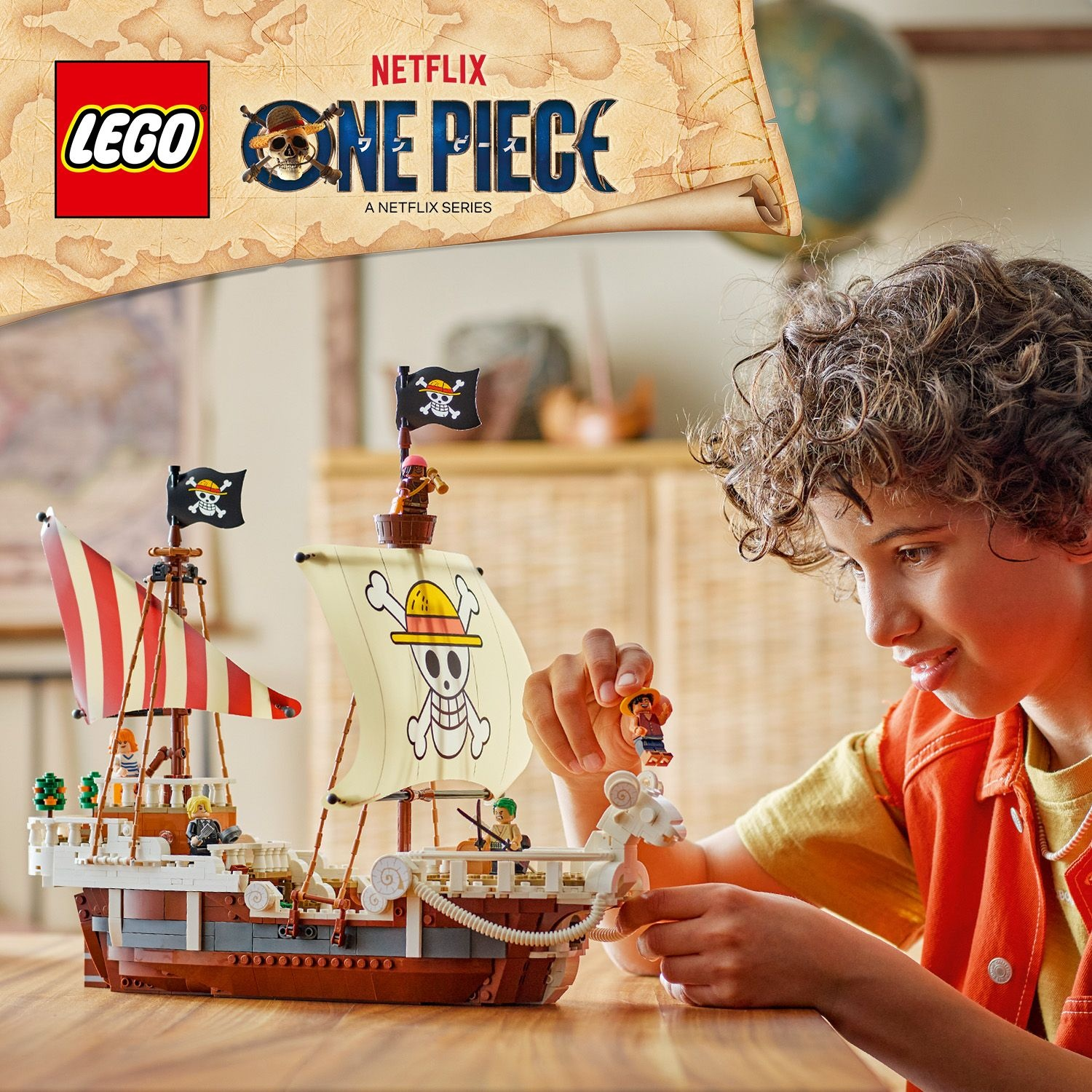 Un ragazzo gioca con una nave pirata Lego One Piece. Il set include personaggi e un modello dettagliato della nave.