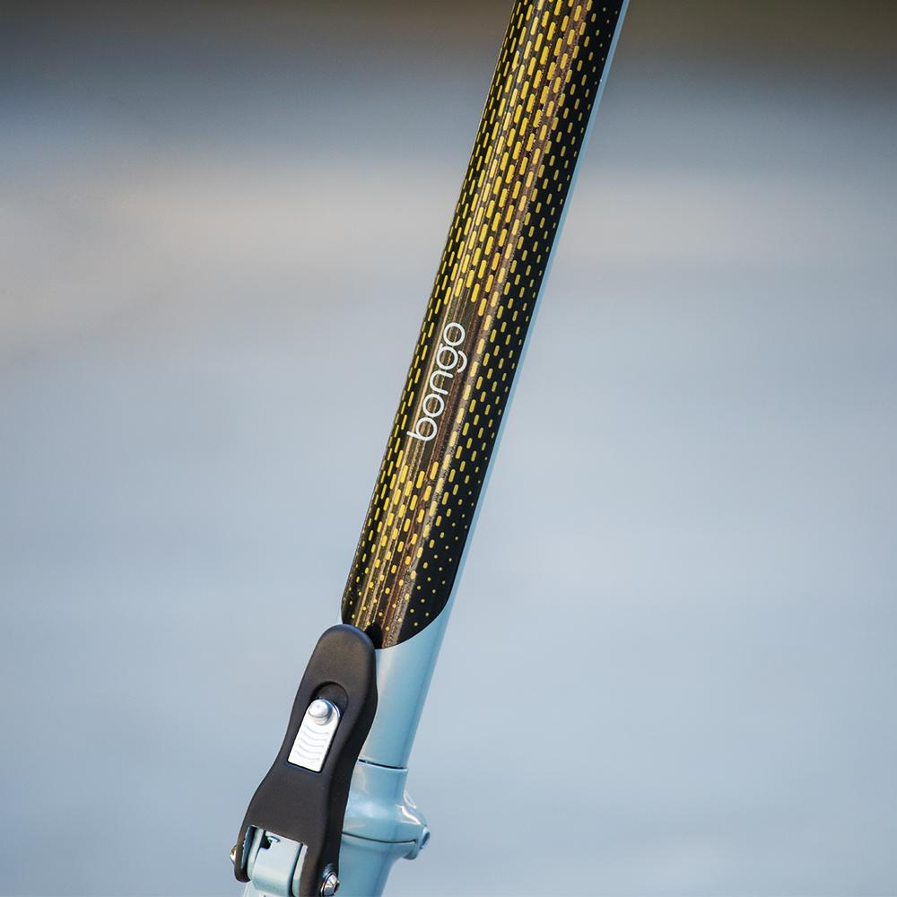 Primer plano del manillar de un patinete. Tiene un agarre con estampado negro y amarillo, la palabra 'bongo' y un mecanismo plegable negro.