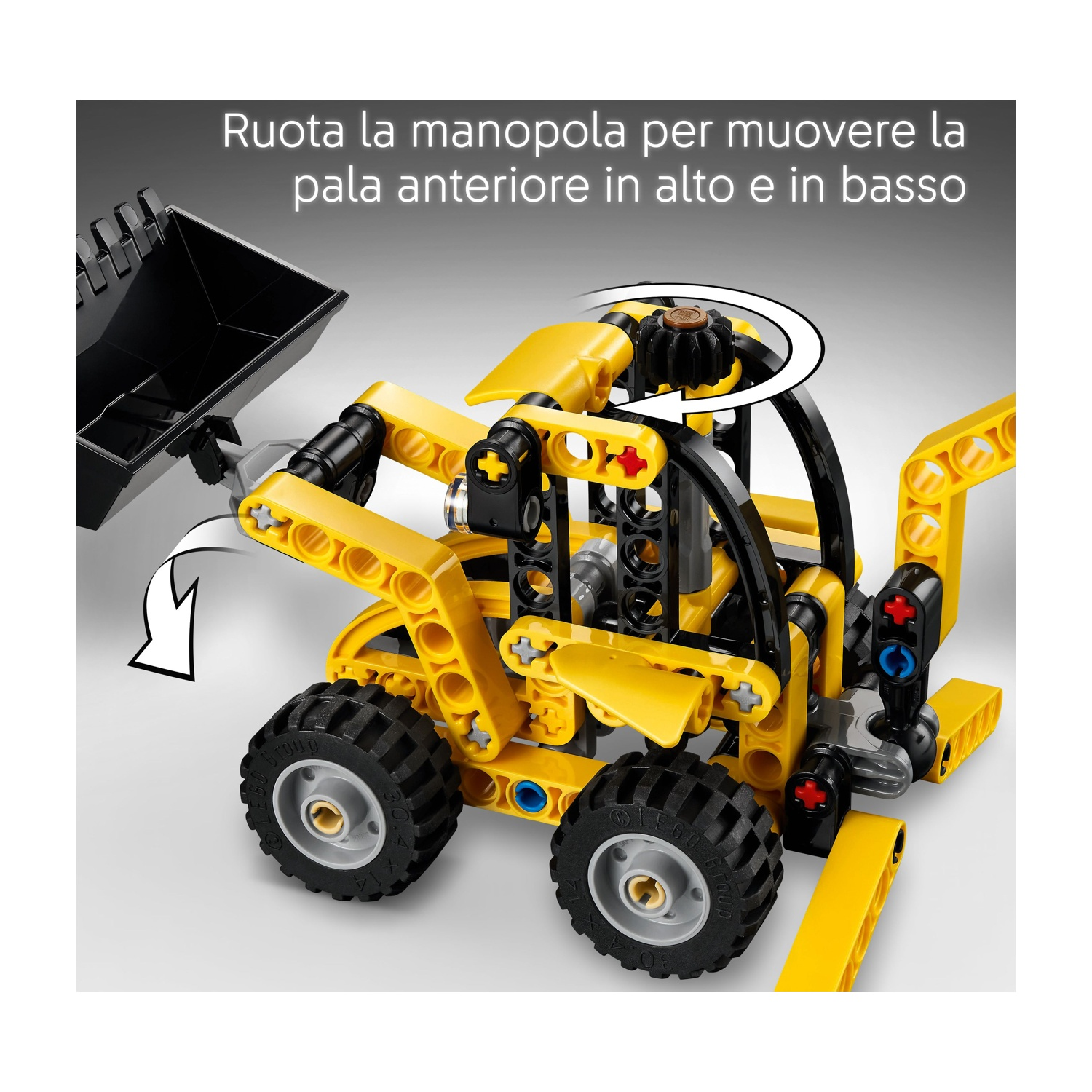 Un escavatore giocattolo giallo e nero con una benna nera. Le ruote sono nere e ci sono istruzioni in italiano in alto.