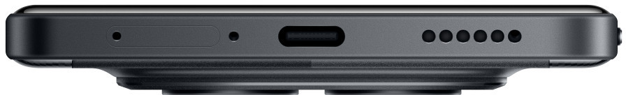 Zbliżenie dolnej krawędzi ciemnoszarego telefonu. Ma port ładowania, otwory głośnikowe, mikrofon i gniazdo karty SIM.