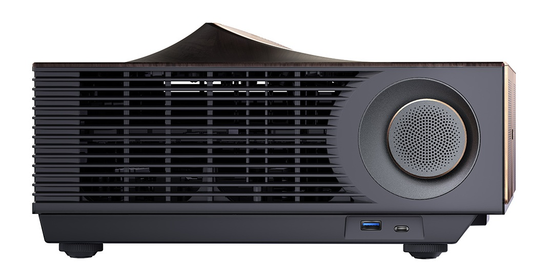 Czarny i szary projektor z blatem z ciemnego drewna. Posiada głośnik, porty USB i kratkę wentylacyjną.