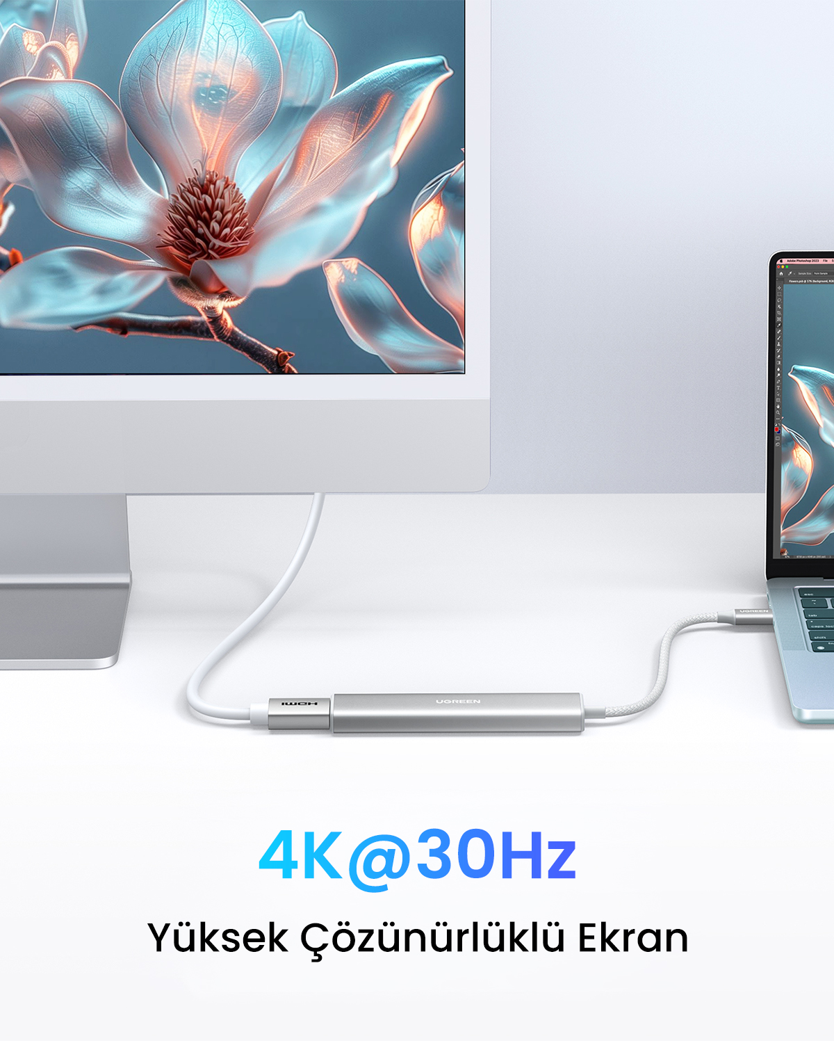 Bir çiçek grafiği gösteren bir monitör, bir kablo aracılığıyla bir dizüstü bilgisayara bağlı bir bilgisayar kurulumu. Arada metal bir adaptör var.