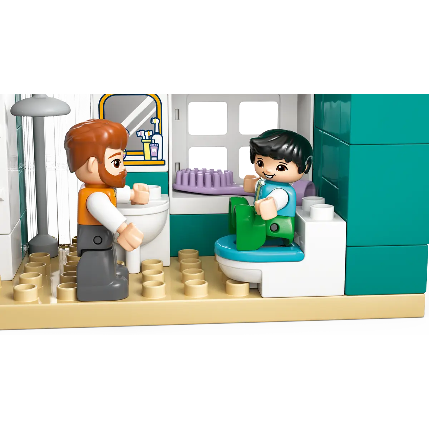 A Lego scene shows a man and a child in a bathroom. The man is near a toilet, while the child is on a green toilet seat.