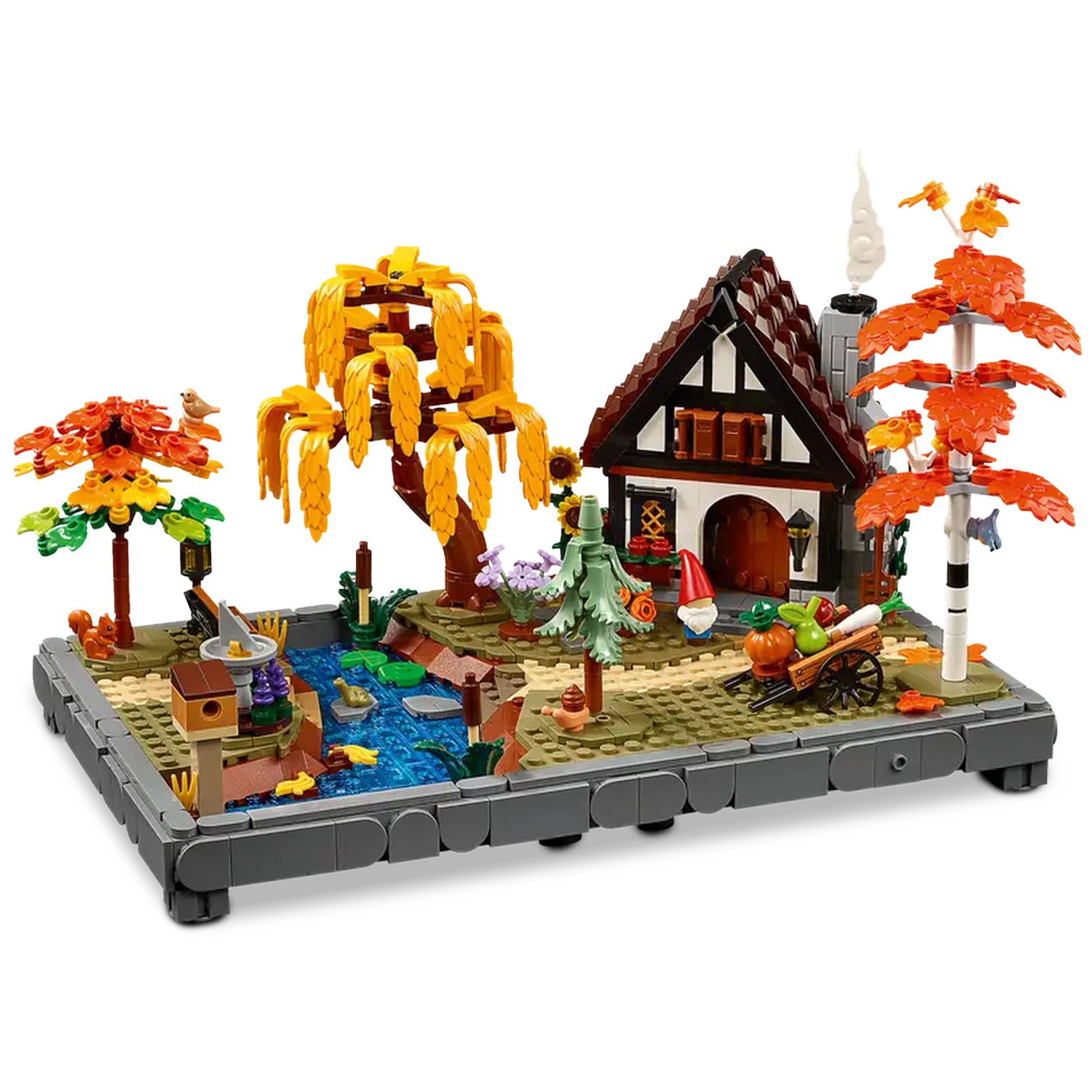 Lego set of a house, pond, and trees in autumn colors. Includes a gnome, cart, and birdhouse. It's a miniature village scene.