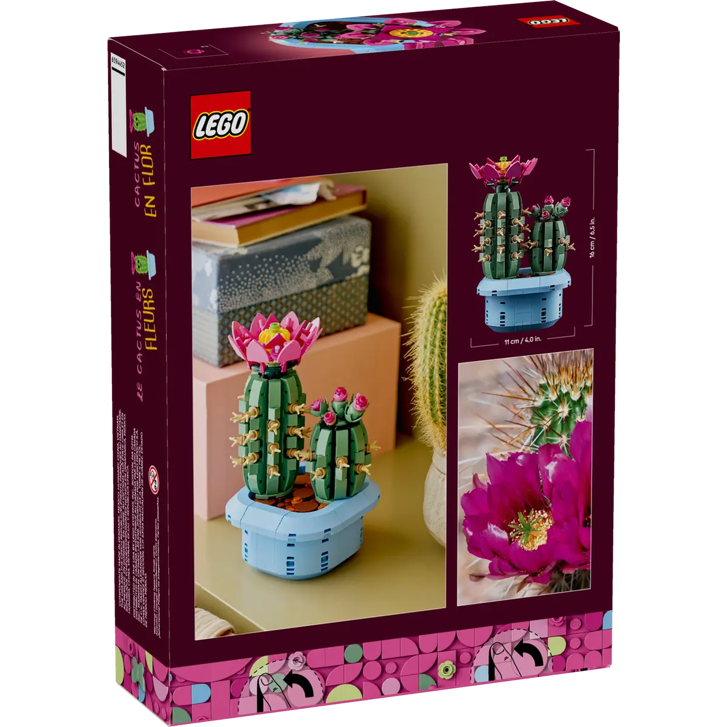 The box shows a Lego set of cactus plants with pink flowers. The background has other objects.